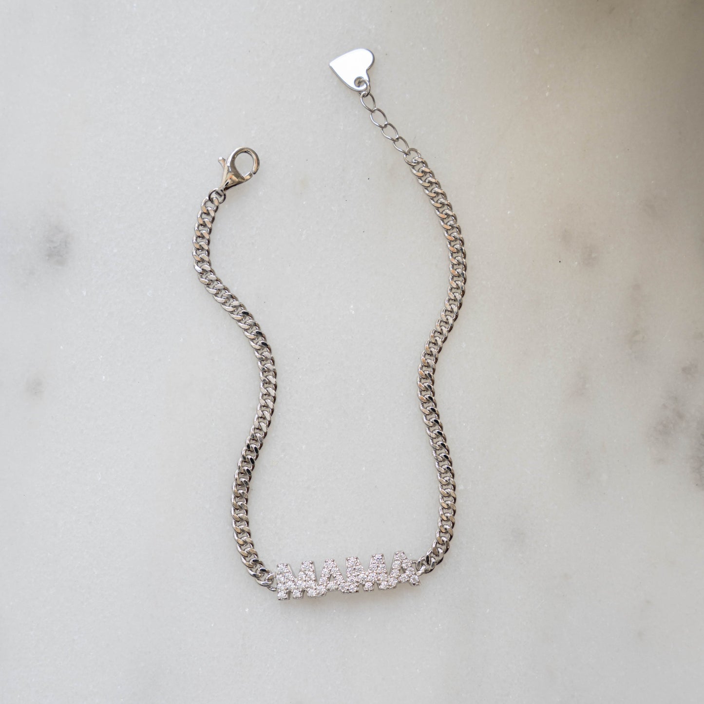 Closeup image of sterling silver bracelet with cuban link chain and a MAMA charm