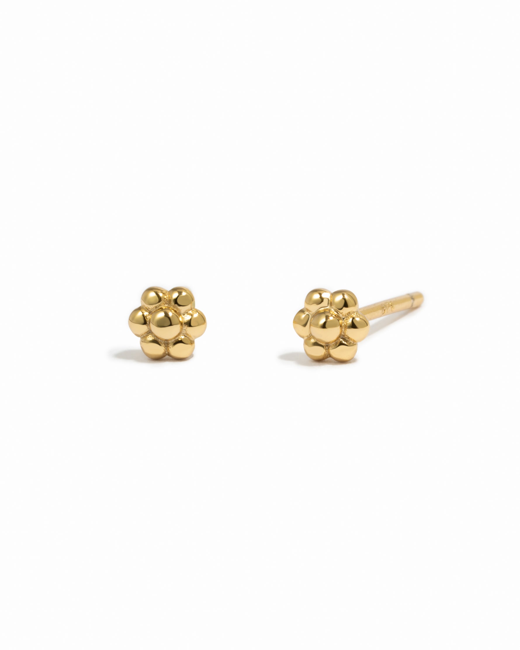 Dainty gold flower stud earrings.