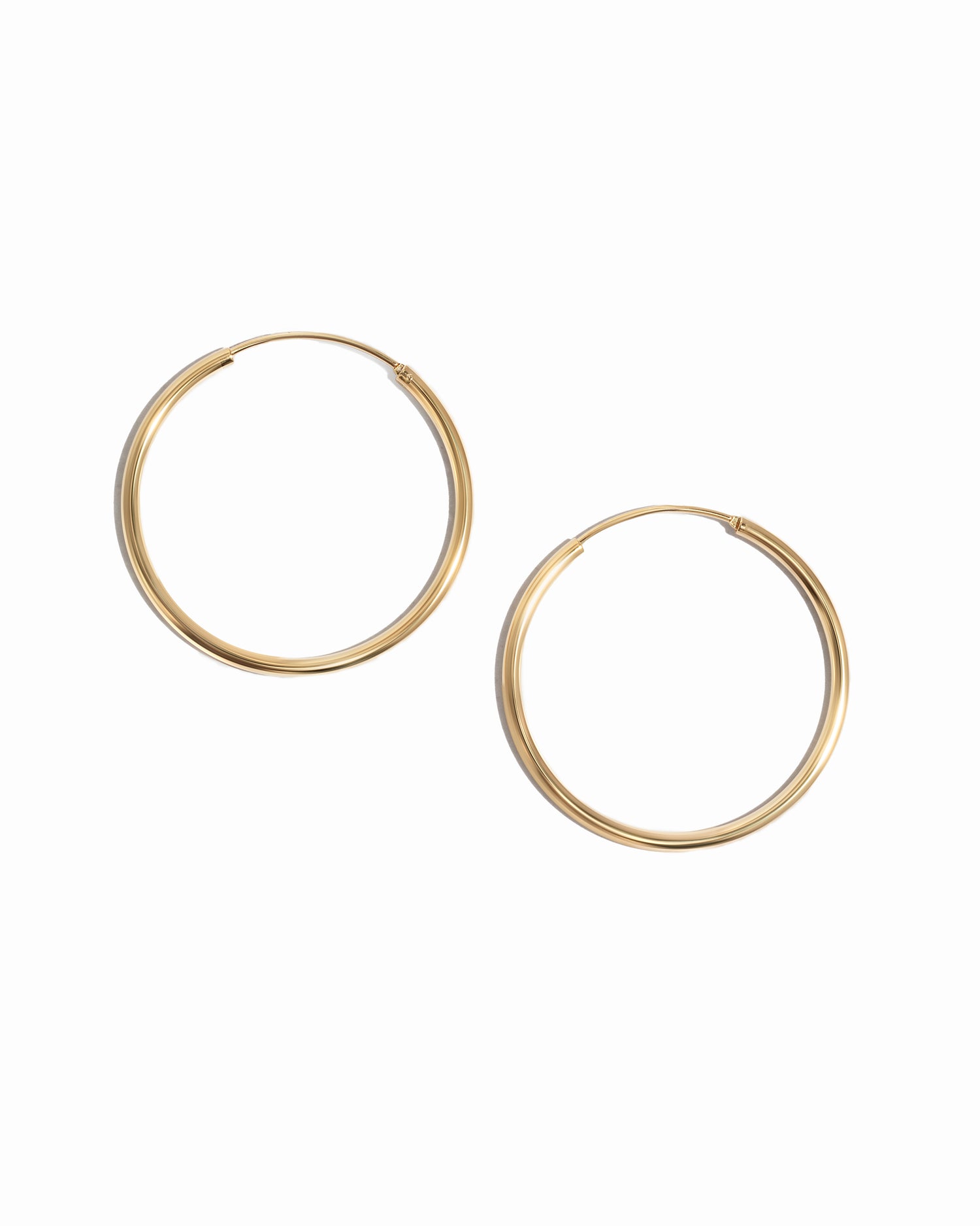 Closeup image of dainty gold hoop earrings