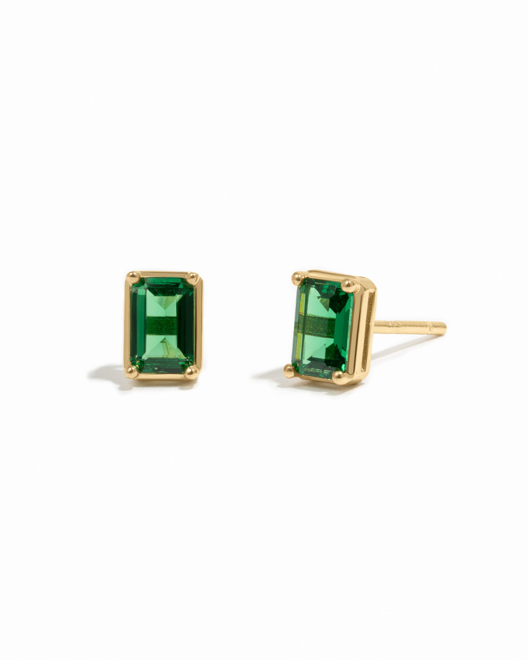 Gold emerald-cut emerald gemstone stud earrings.