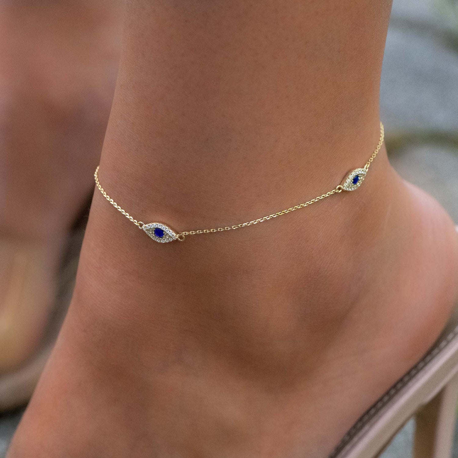 Model wearing gorgeous gold evil eye charm anklet
