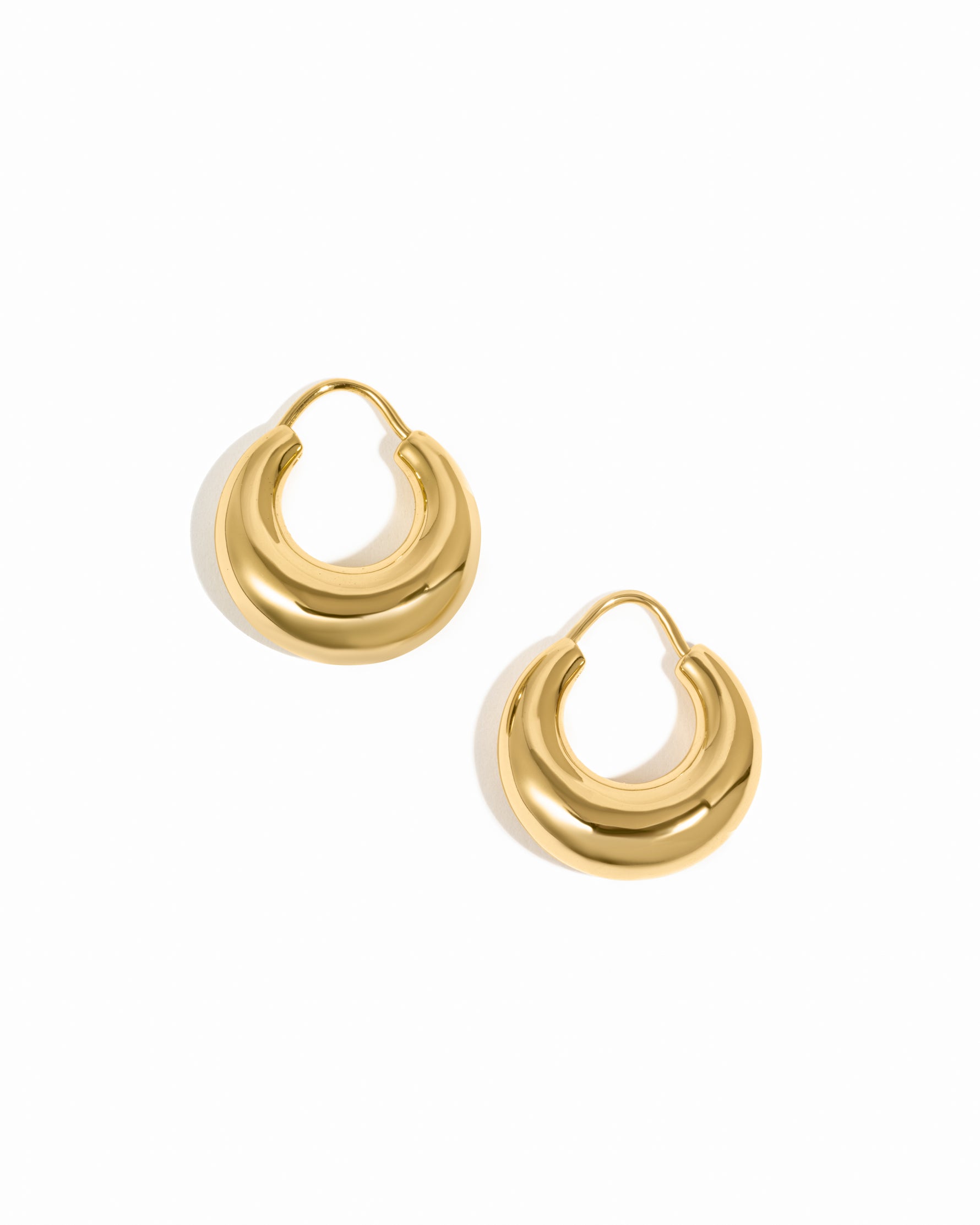 Sleek gold chunky basket hoop earrings on white background.