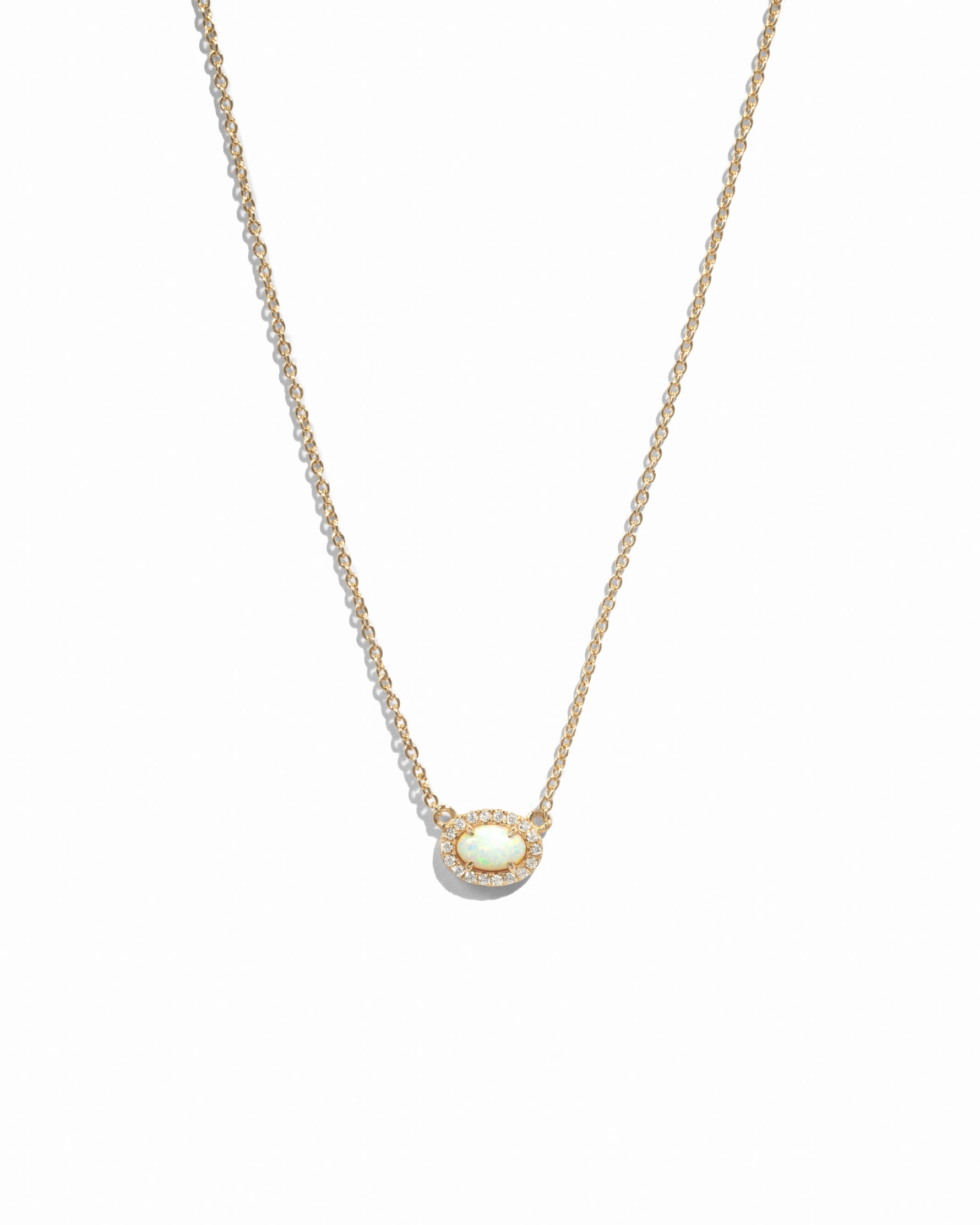 Delicate gold chain with opal oval halo pendant on white background