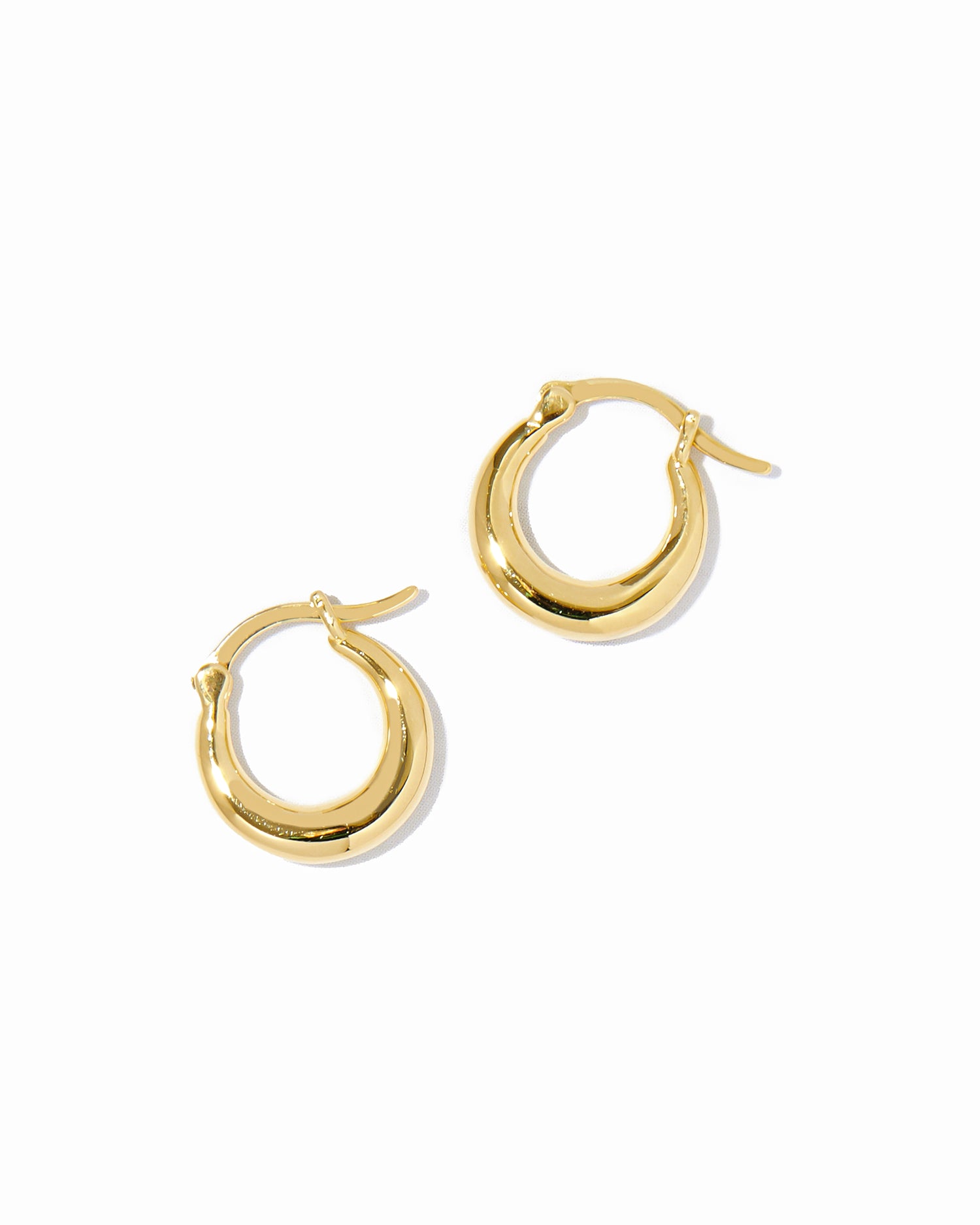 Dainty gold 14k plated basket huggie hoop earrings on white background.