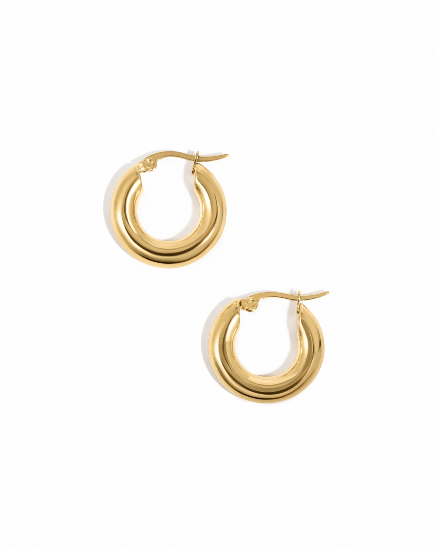 Gold chunky everyday tube hoop earrings on white background.