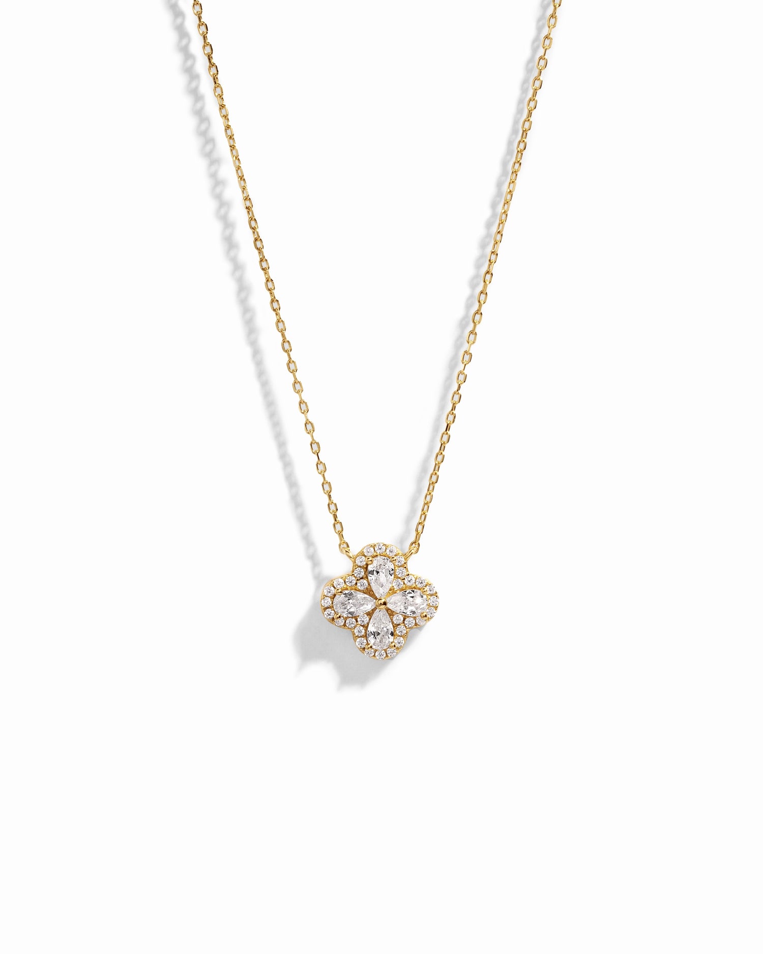 Close-up of four leaf clover pendant inspired by Van Cleef, highlighting intricate diamond details of pear shaped stones made of cubic zirconia.