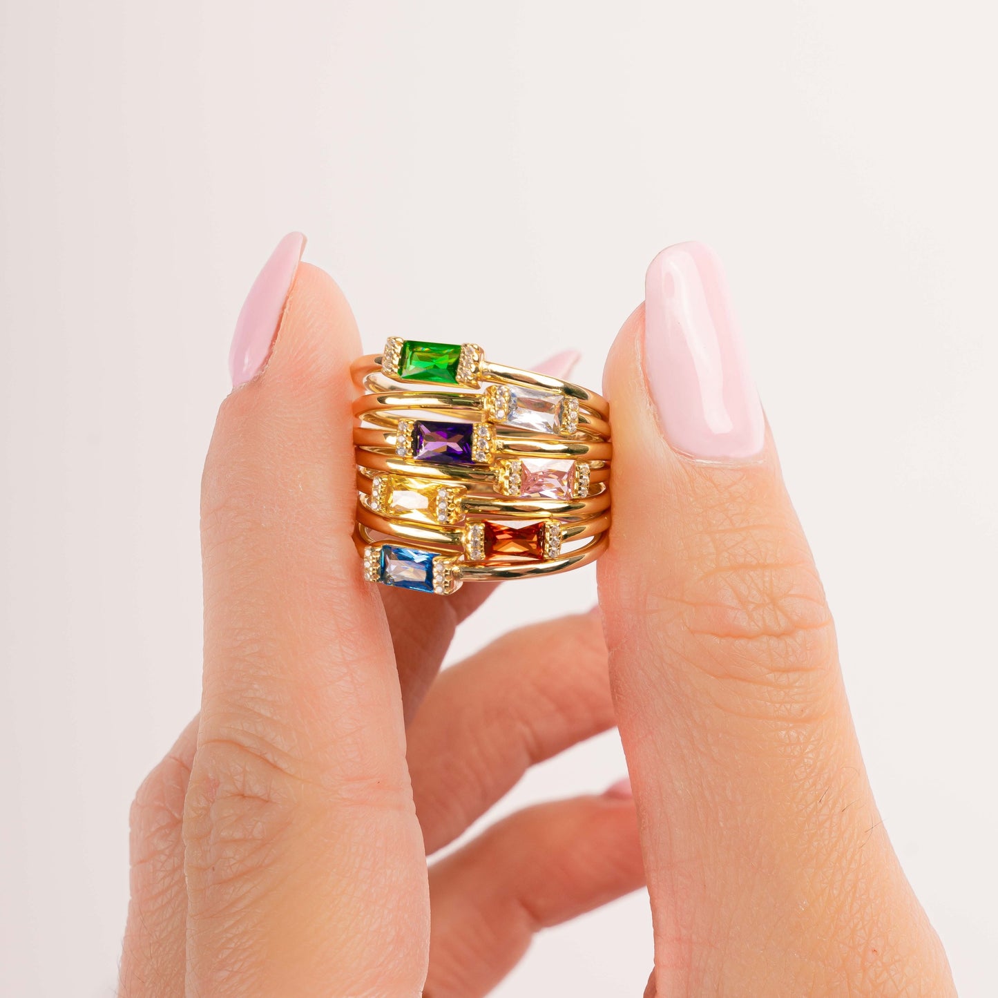 Model holding dainty 14k gold plated baguette birthstone rings from Sami Jewels