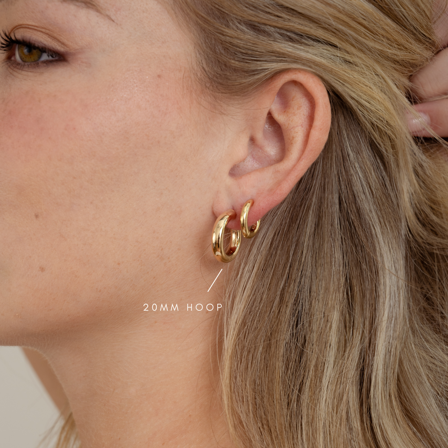 20mm tube hoops on model paired with a minimalist huggie hoop