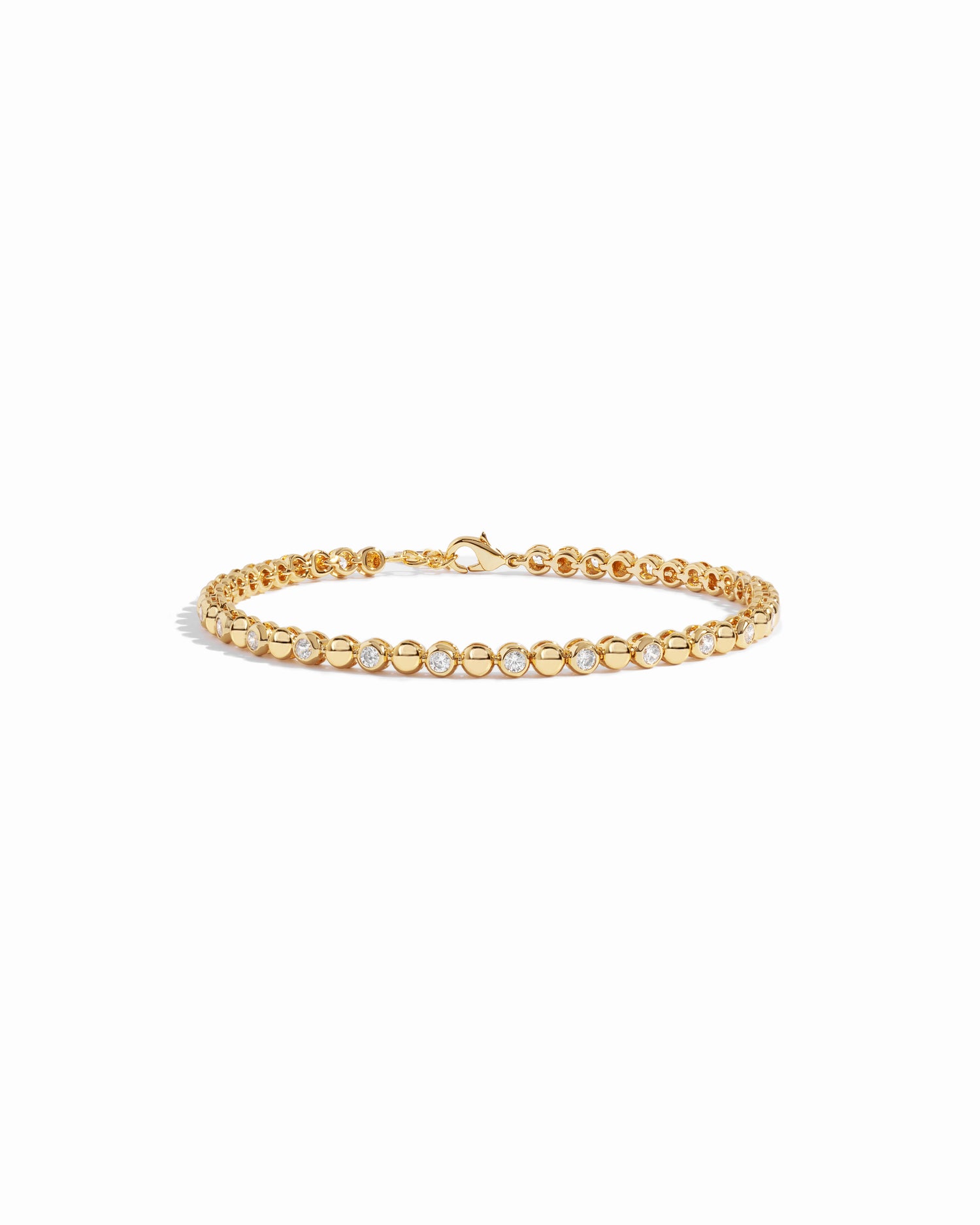 Gold bezel cz tennis bracelet on white background