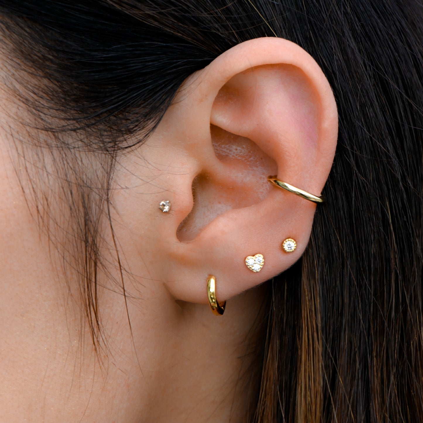 model wearing gold earring stack with plain ear cuff