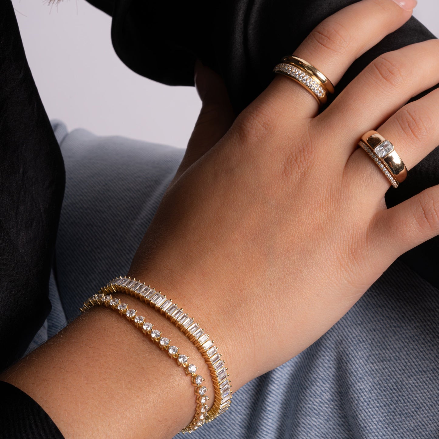 model wearing gold jewelry featuring gold baguette cubic zirconia dome ring