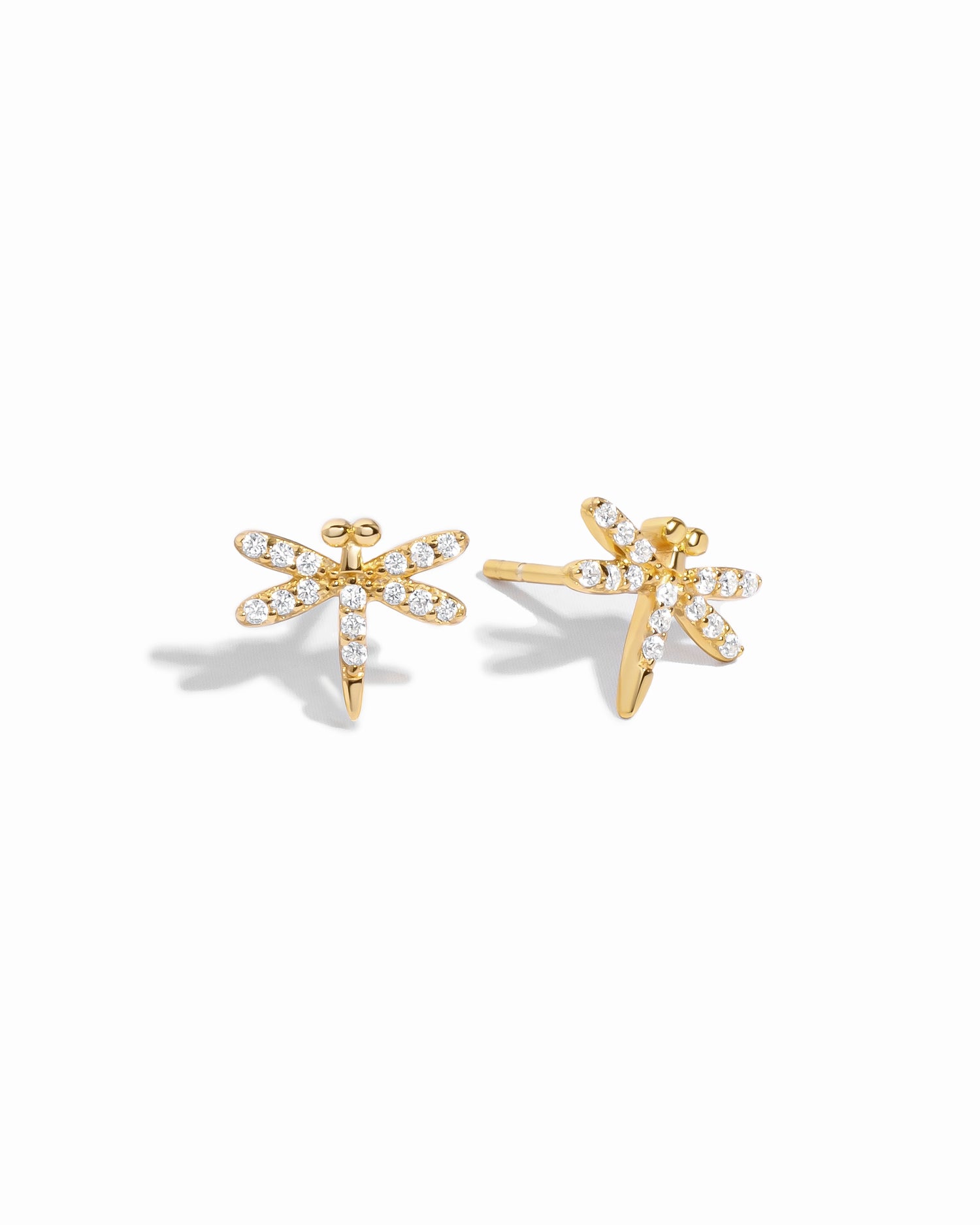 Gold dragonfly earrings with cubic zirconia gemstones on a white background