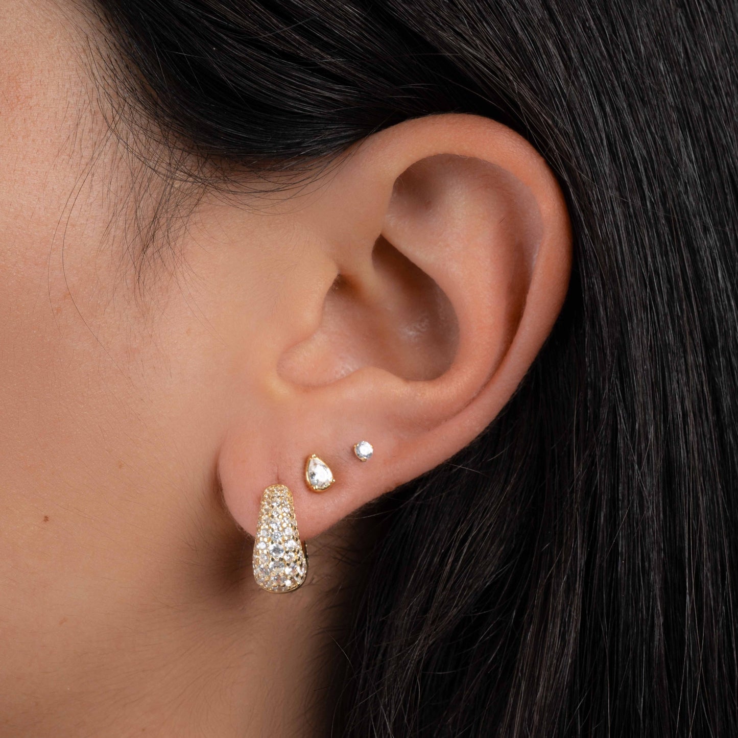 Model wearing 14k gold plated diamond earrings featuring chunky gold hoop earrings