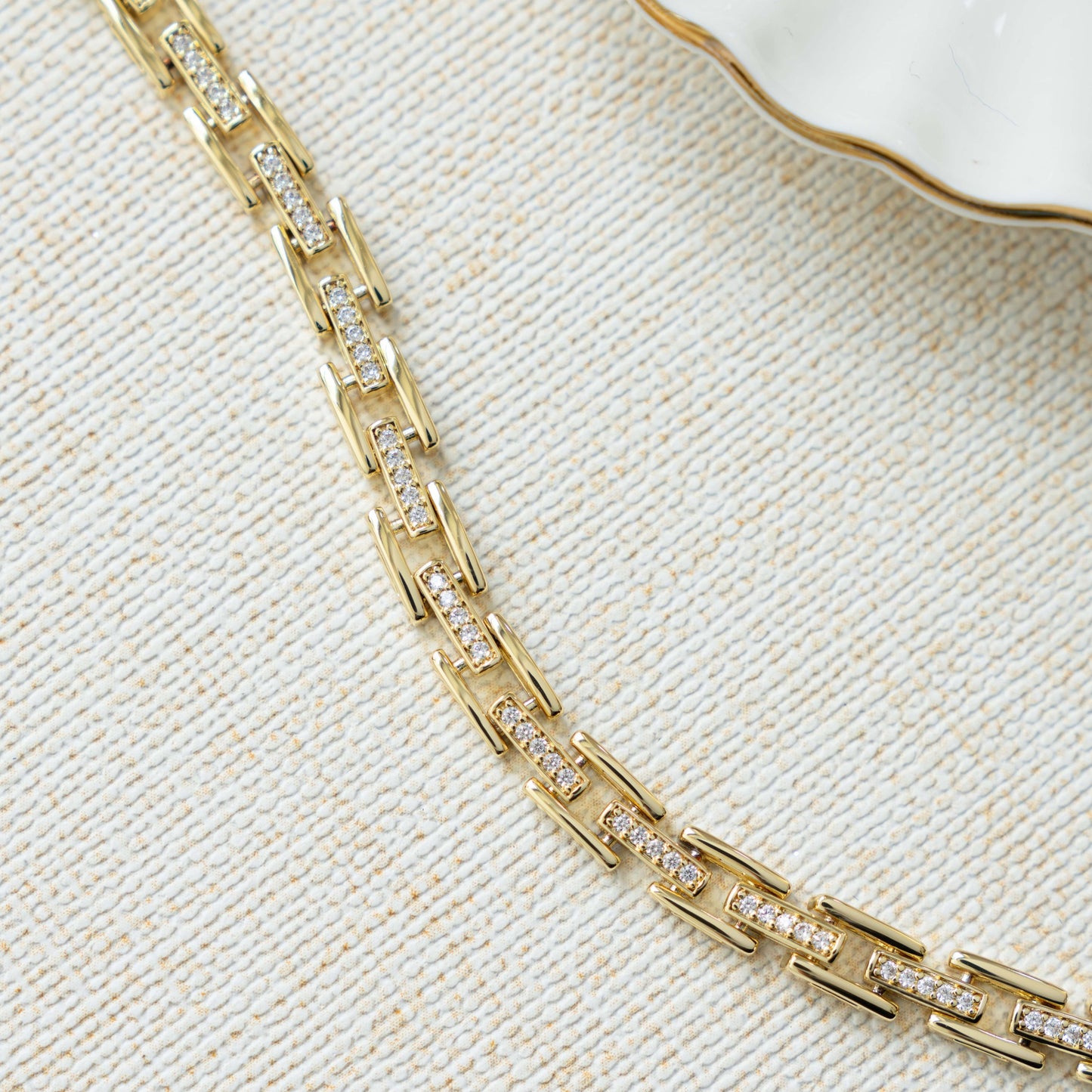 Flatlay image of chunky gold bracelet with chain link bracelet design