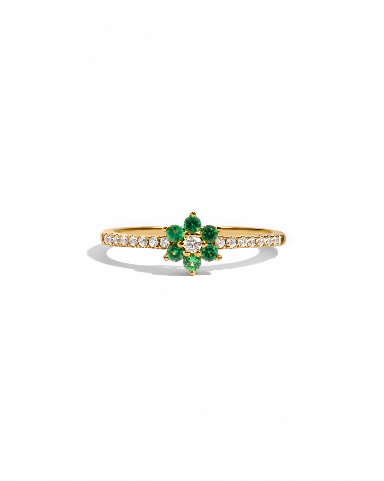 Gold ring with emerald green gemstone on a white background