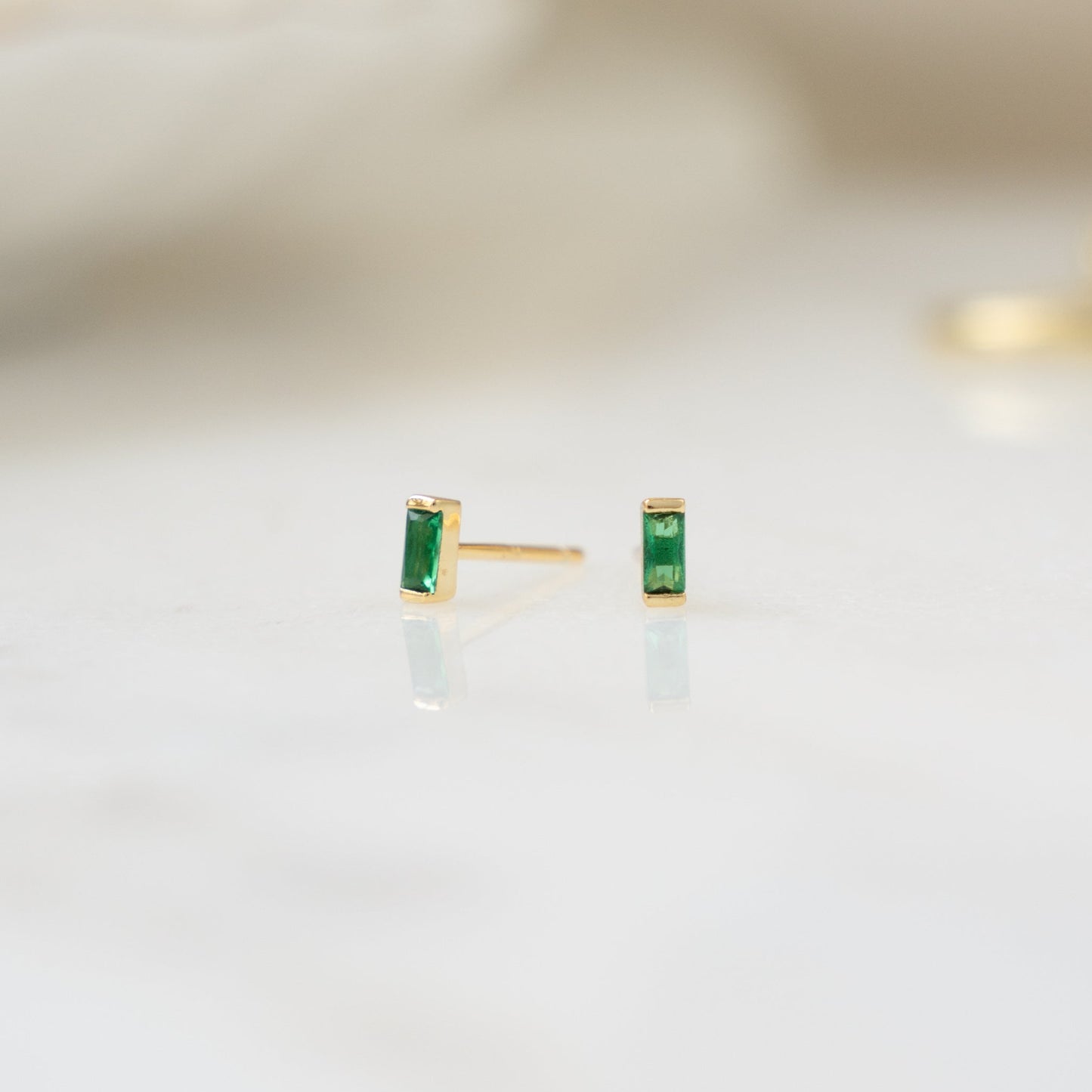 closeup image of gold emerald earrings
