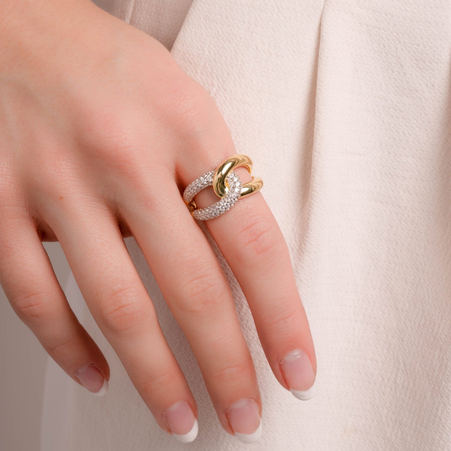 Model wearing criss cross ring in gold and sterling silver