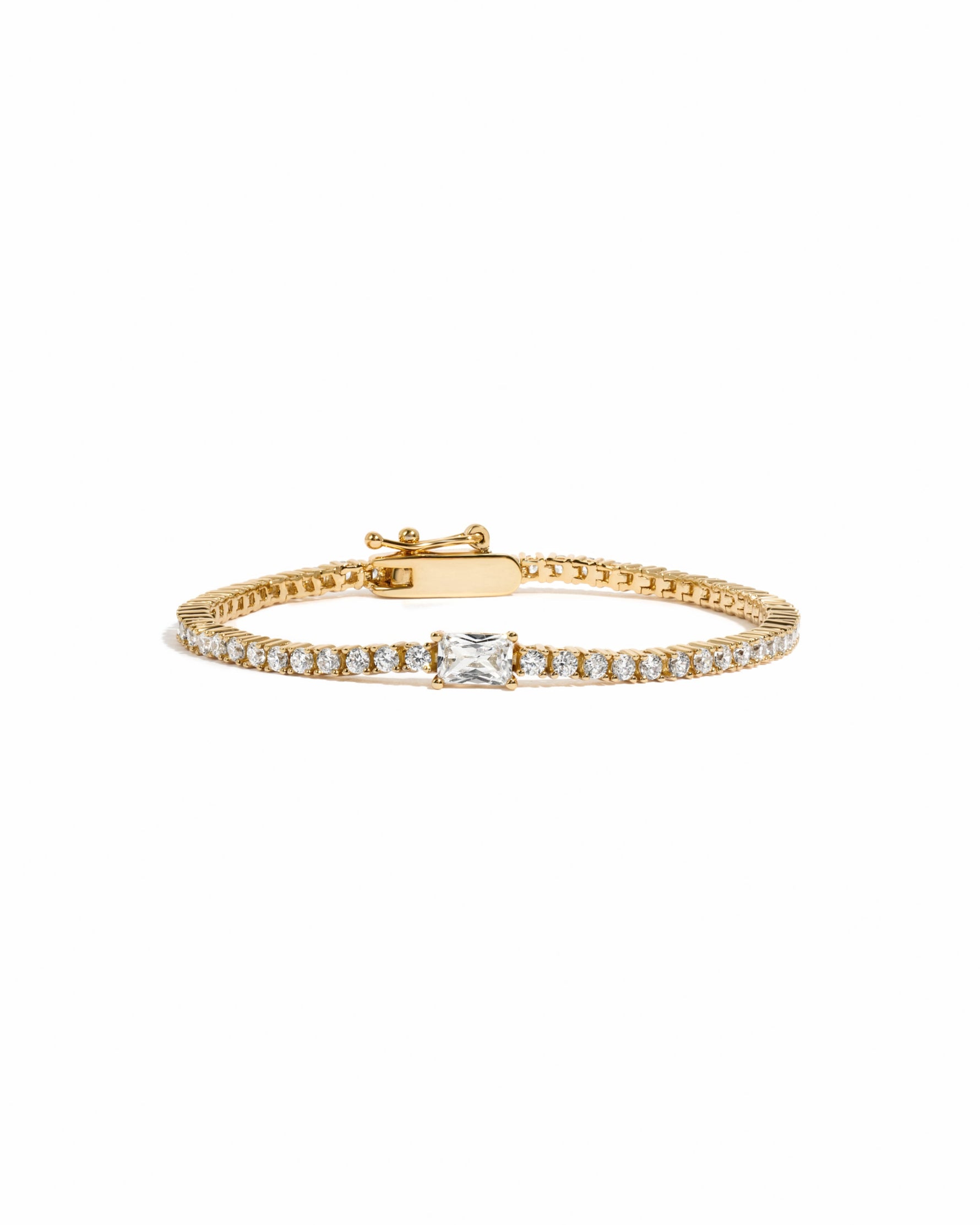 Gold bracelet with a baguette diamond on a white background