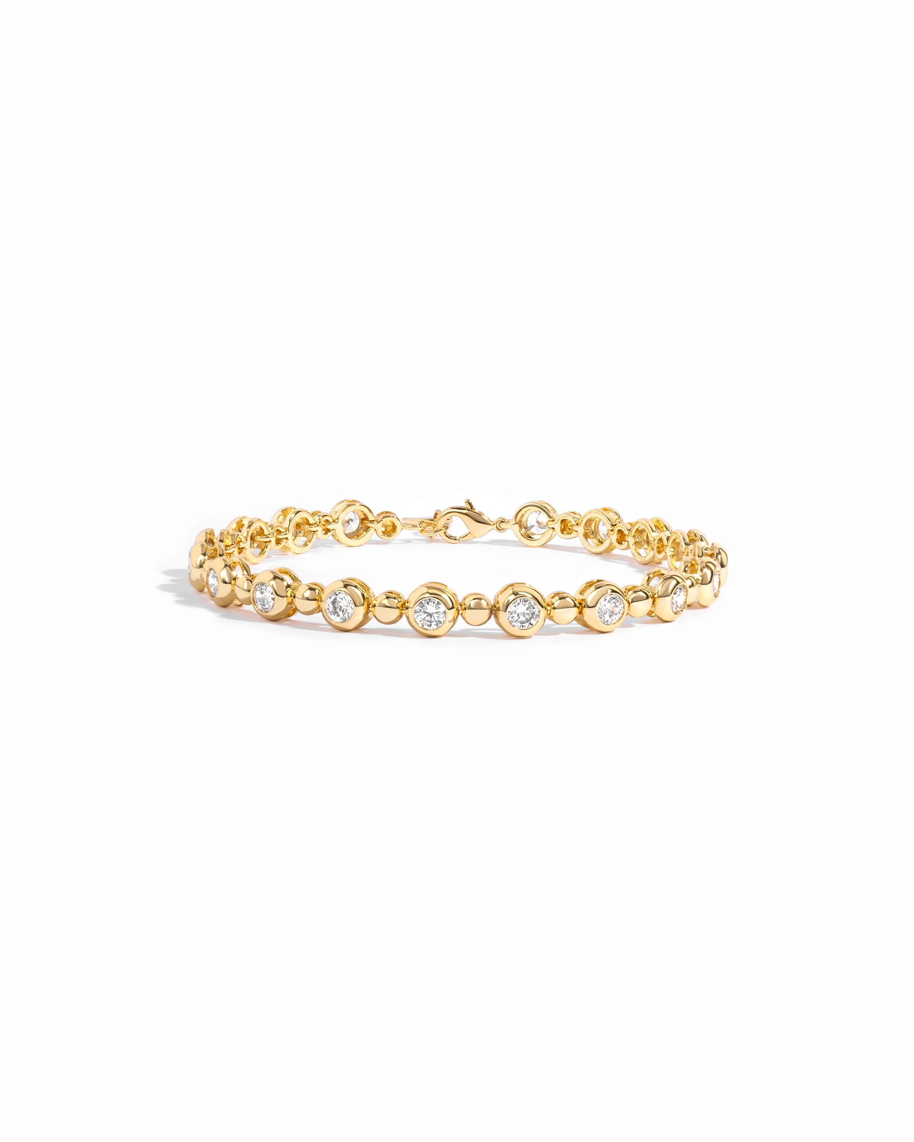 Gold tennis bracelet with bead and bezel accents.