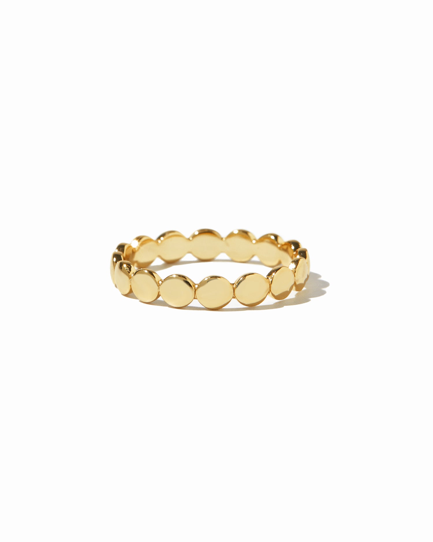 Gold ring with a textured flat beaded band on a white background