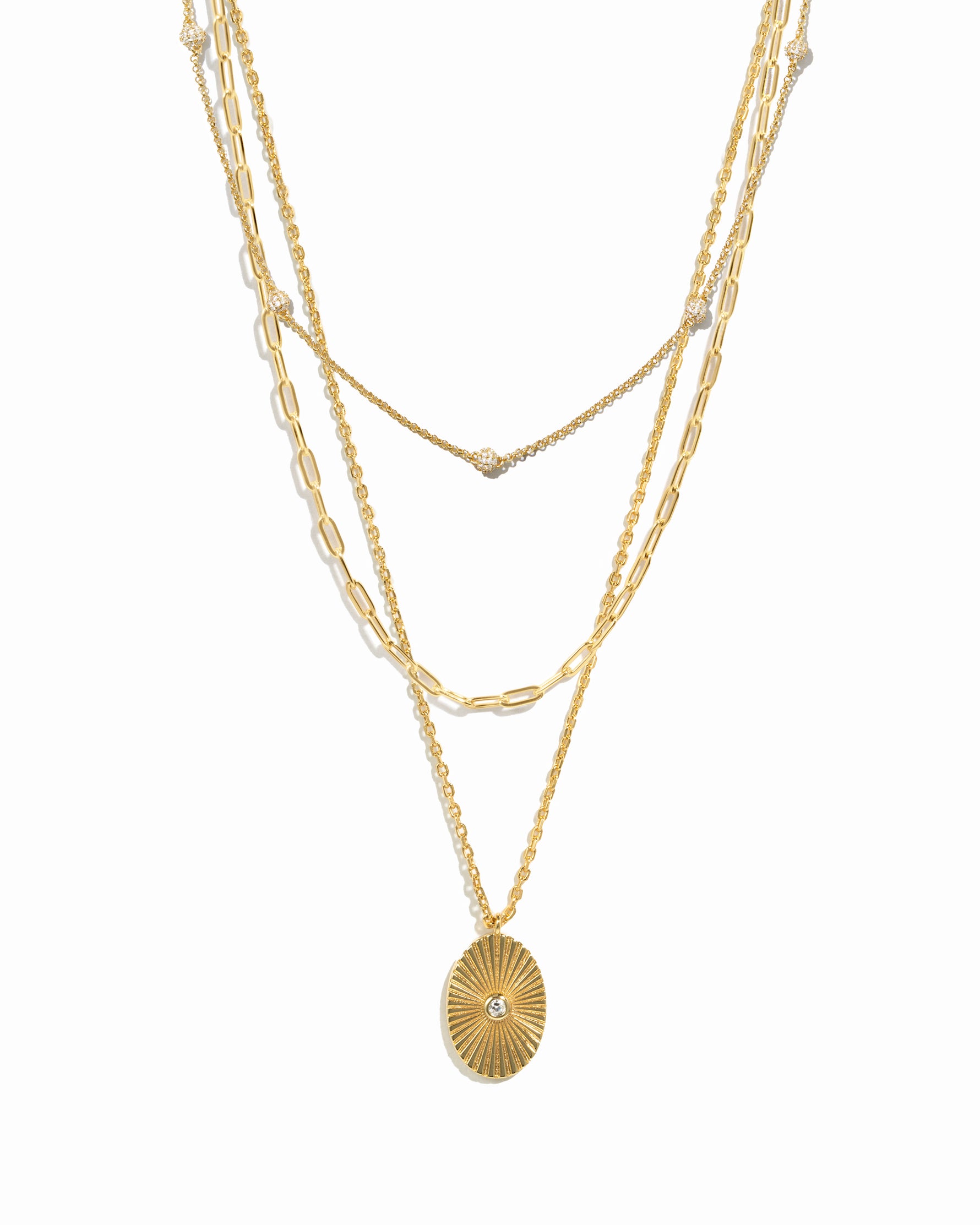 Gold layered chain necklaces with a paperclip chain and beaded necklace design, and a gold central pendant necklace on a white background