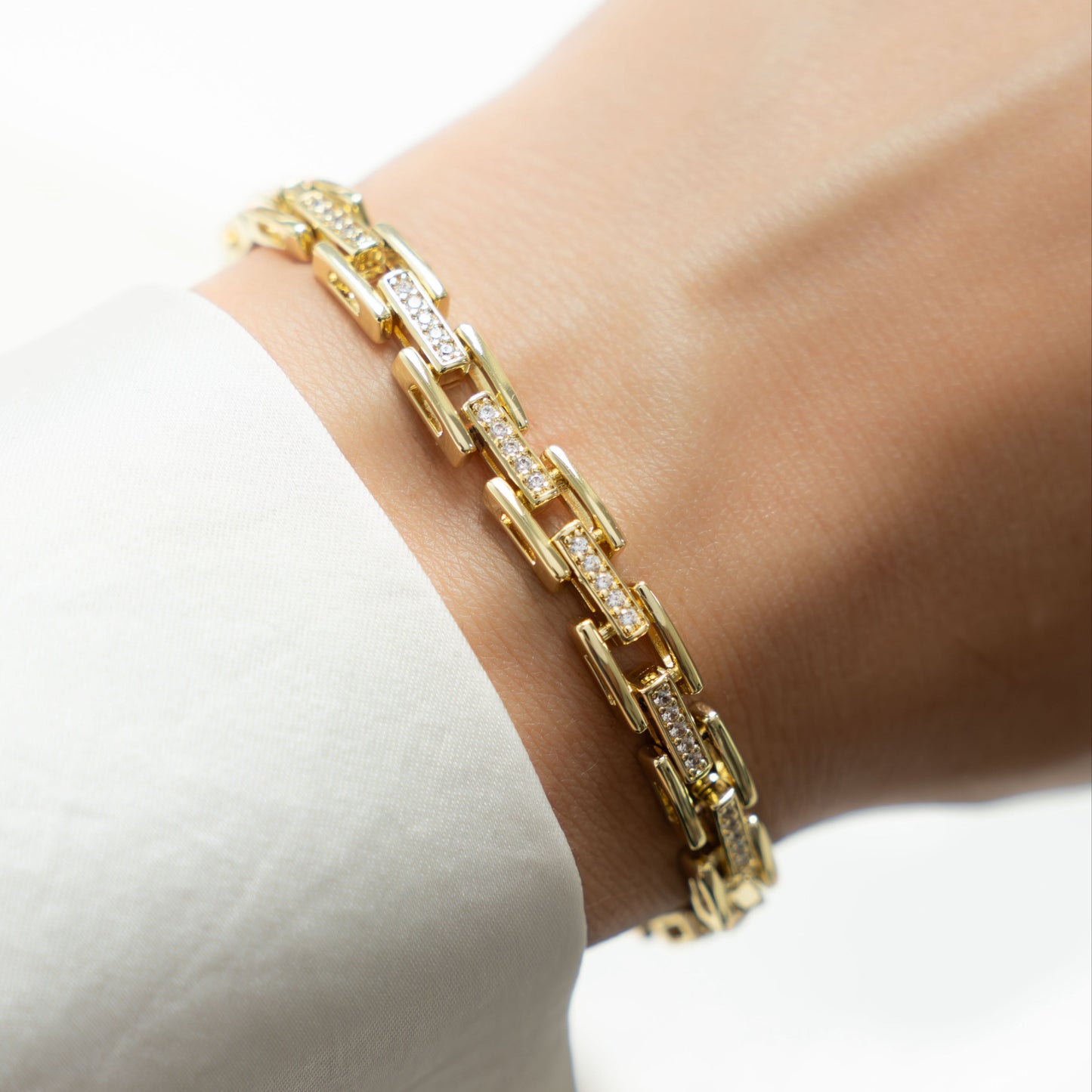 Model wearing gold chain bracelet with cz diamonds