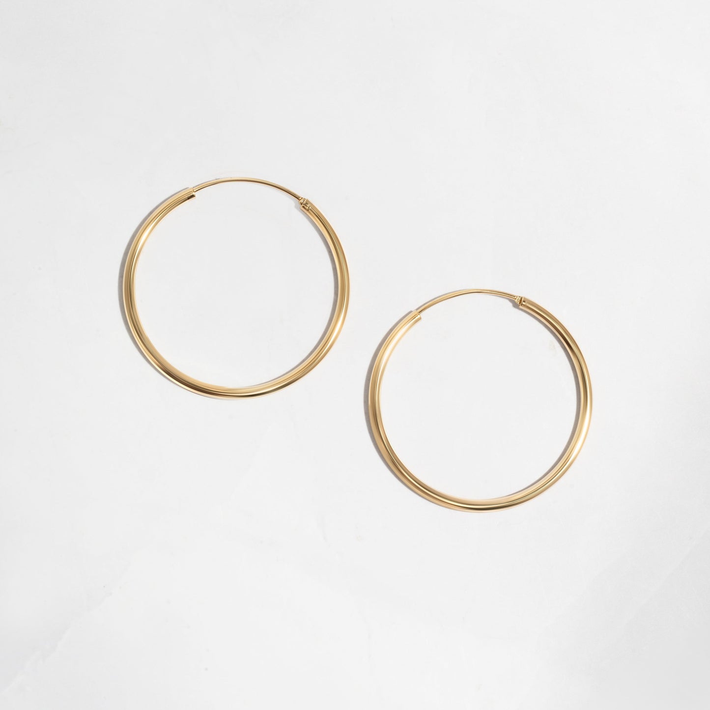 Closeup image of dainty gold hoop earrings