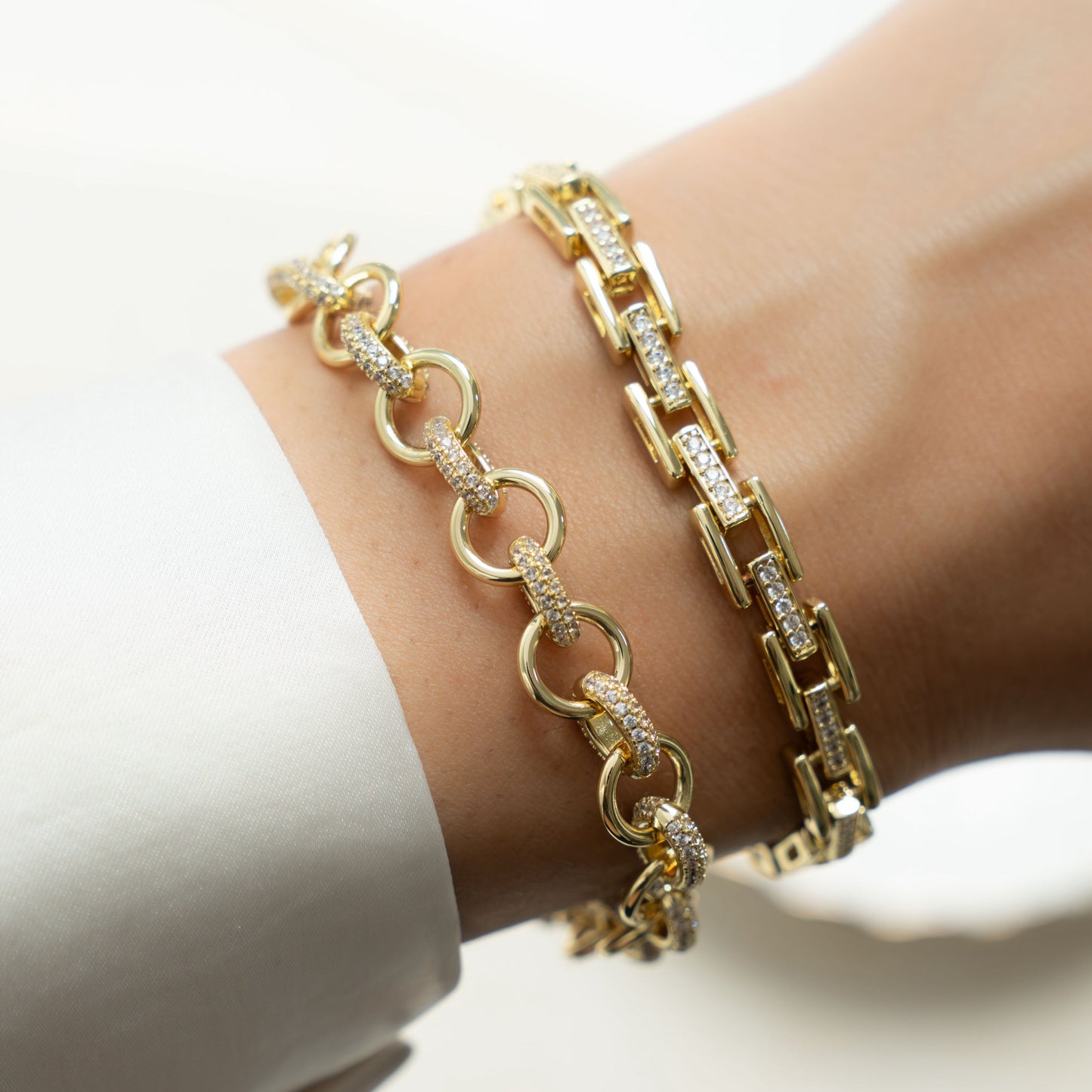 Model wearing statement jewelry featuring gold chain link bracelet with cubic zirconia diamonds