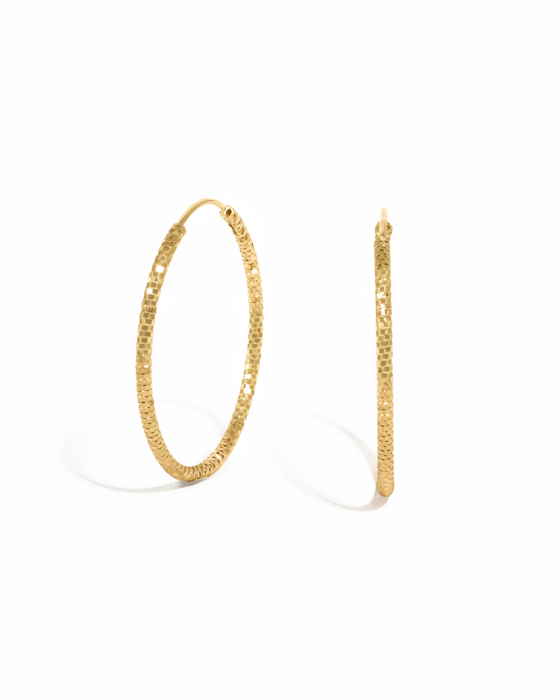 Gold hoop simple everyday earrings on a white background