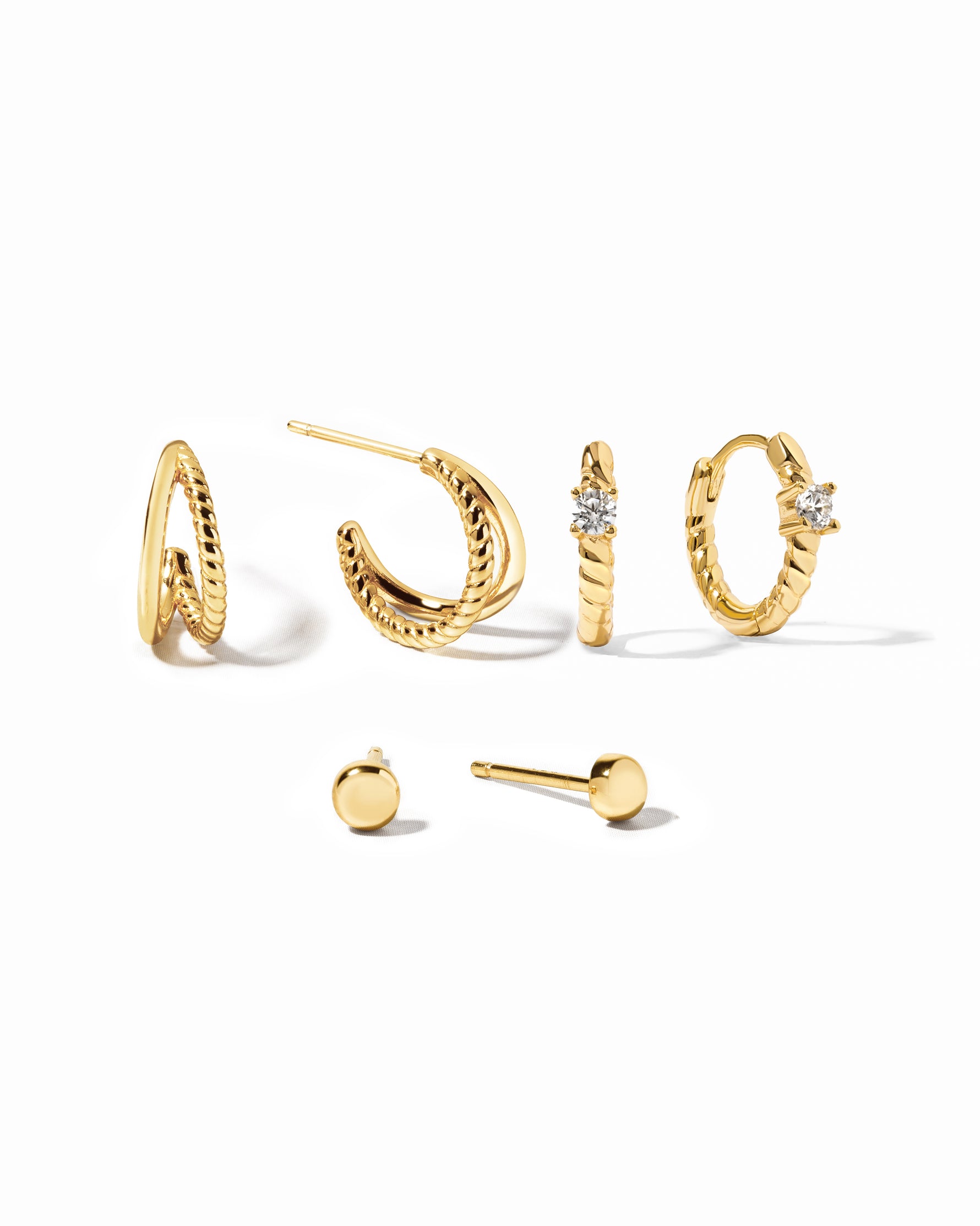 Set of gold earrings on a white background