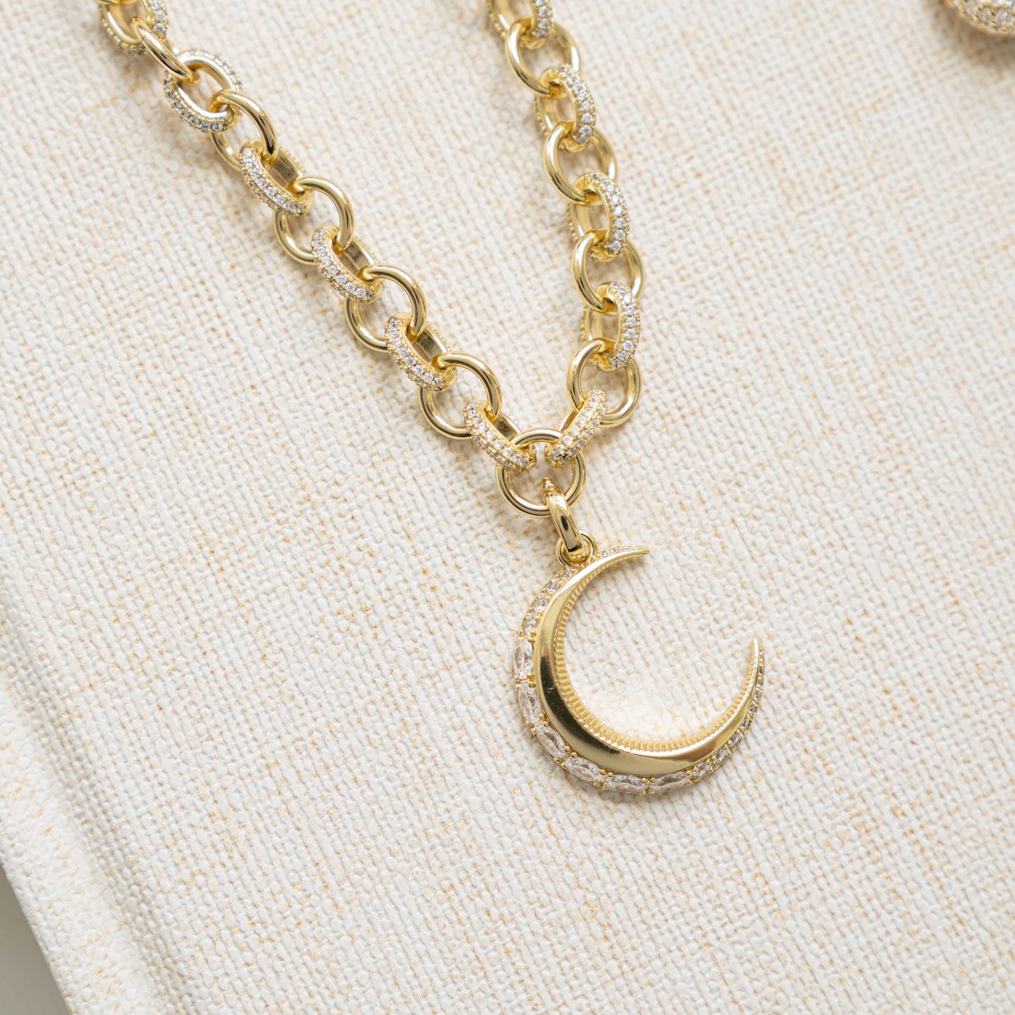 closeup image of gold moon necklace with diamond gold chain