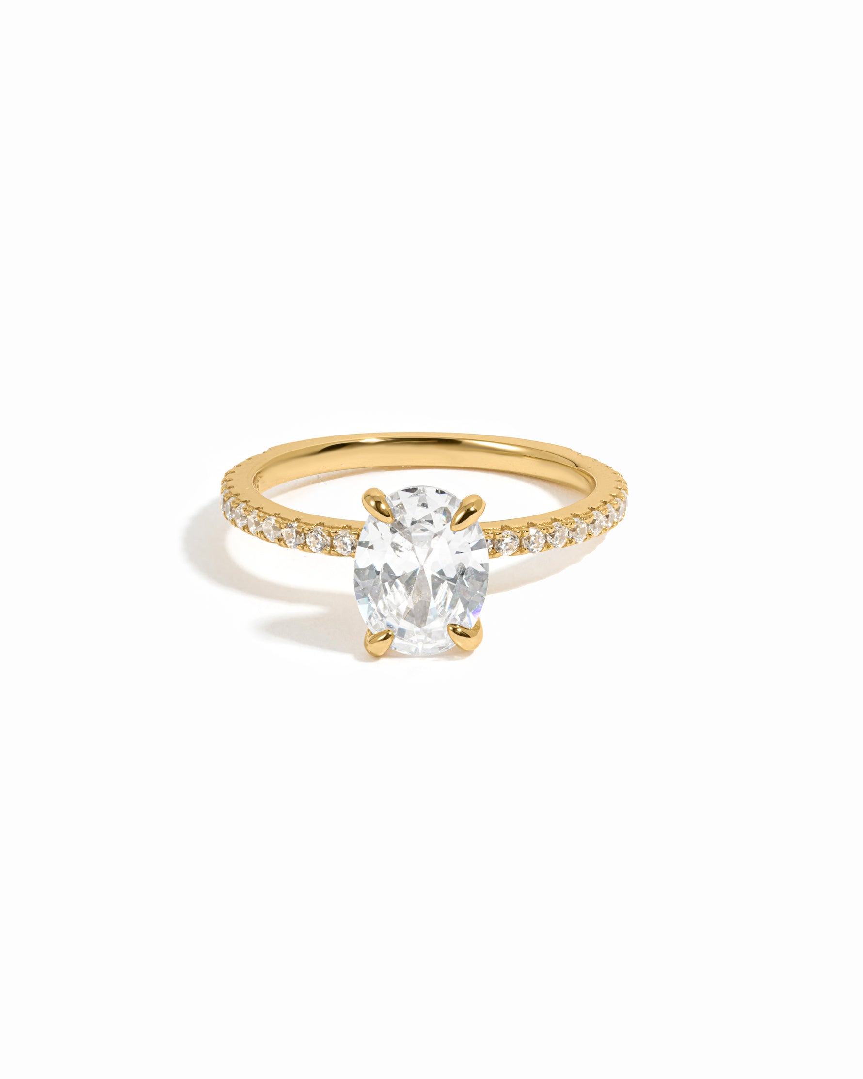 Gold engagement ring with diamond band on a white background