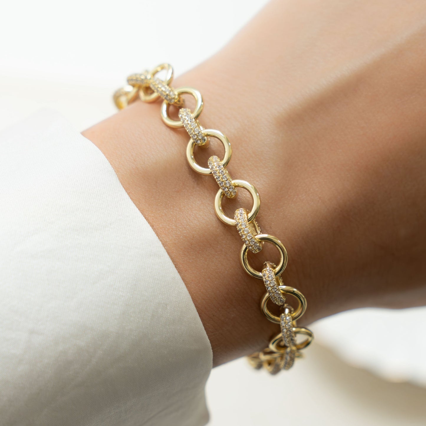 Model wearing gold chain bracelet with cubic zirconia diamonds