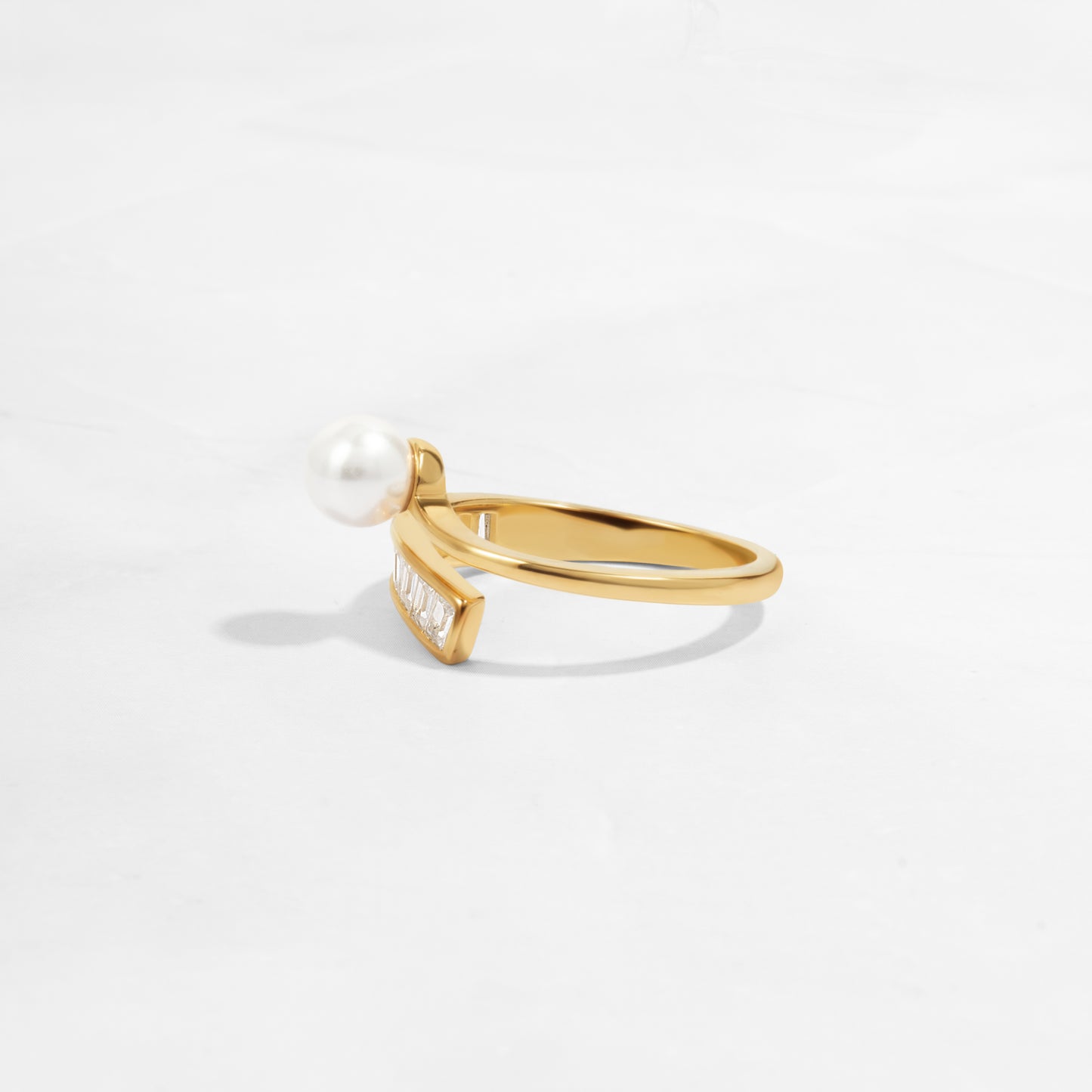 side view of 14k gold plated ring with wrap ring design, with freshwater pearl and baguette diamonds