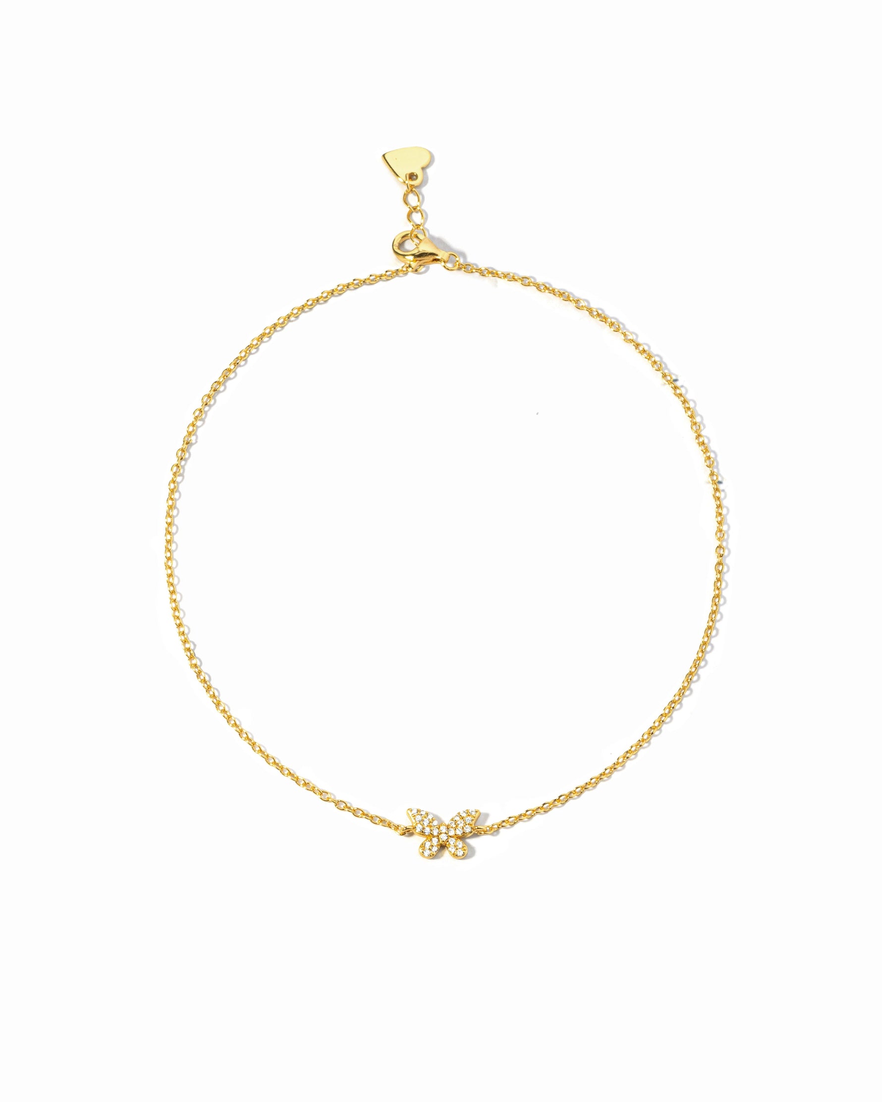 Gold bracelet with a small butterfly charm on a white background