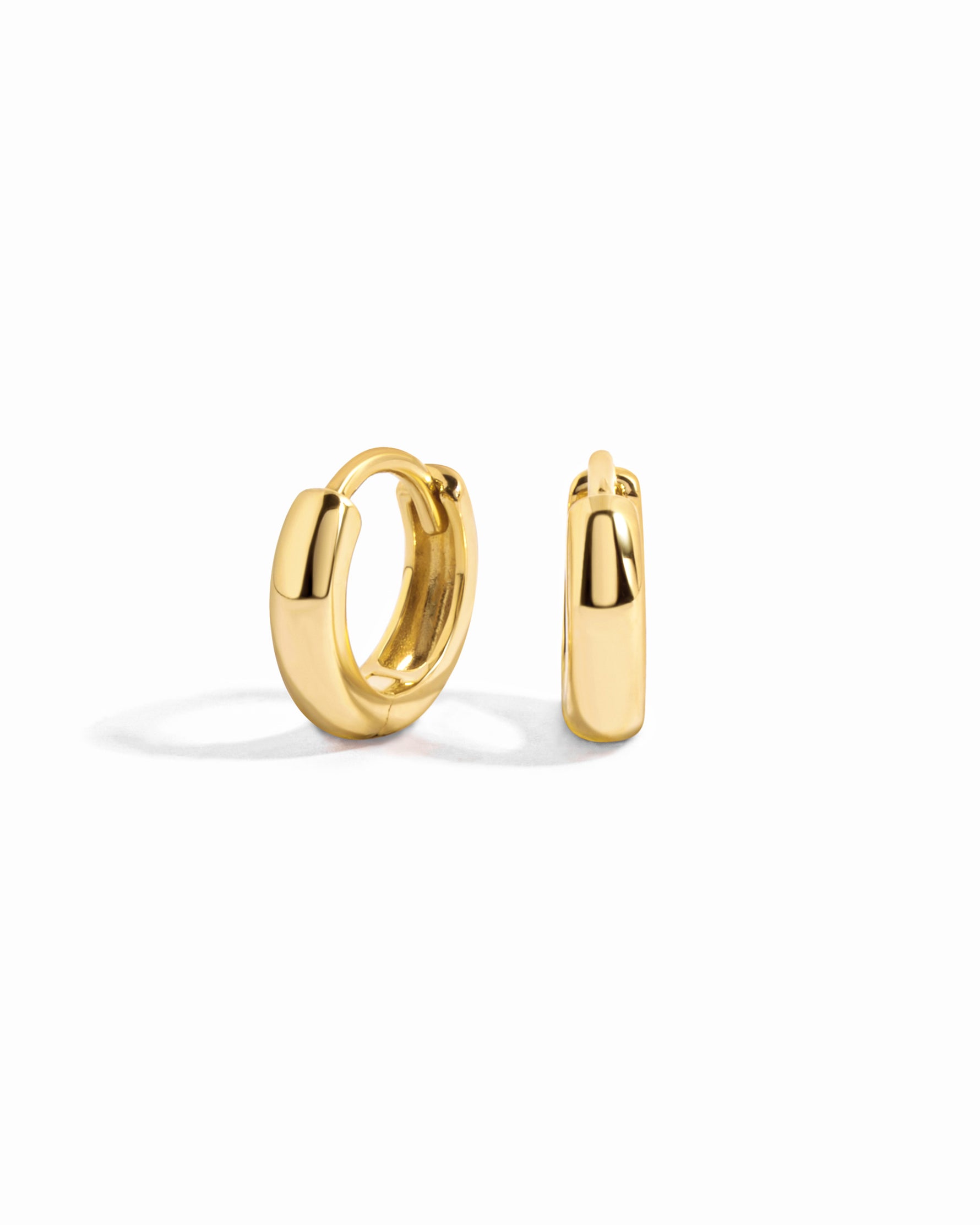 Small gold chunky hoop earrings on a white background