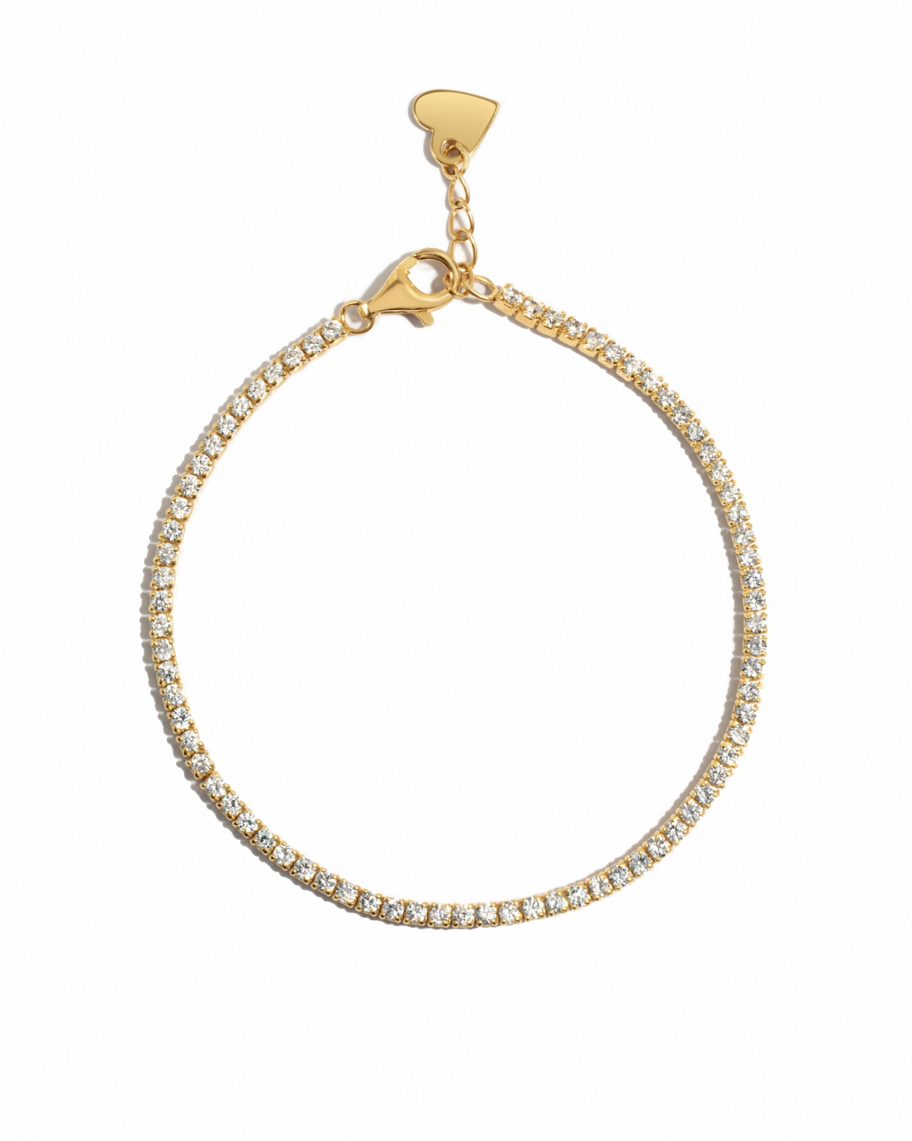 Delicate gold tennis bracelet on a white background