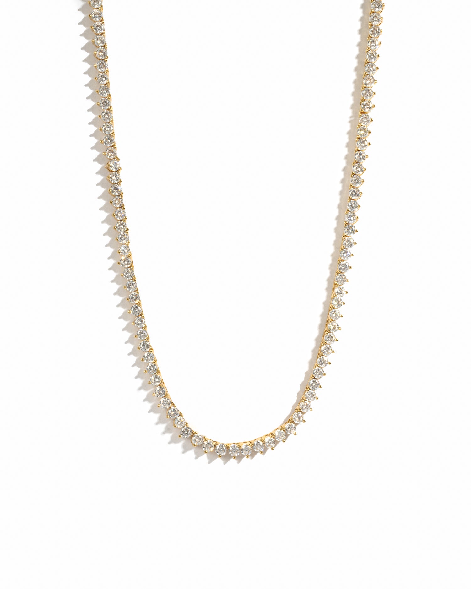 Gold necklace with small white cz diamonds on a white background