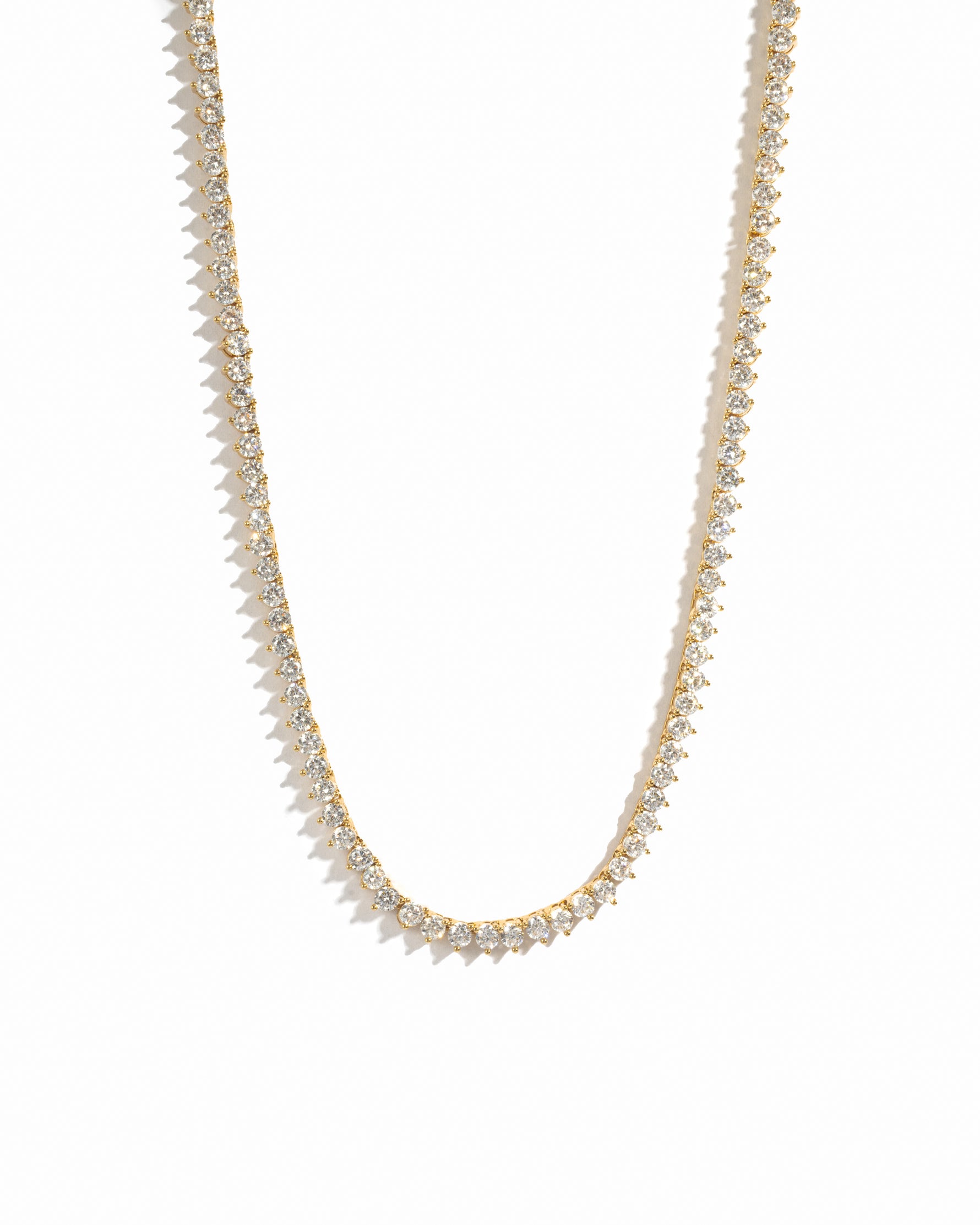 Gold necklace with small white cz diamonds on a white background