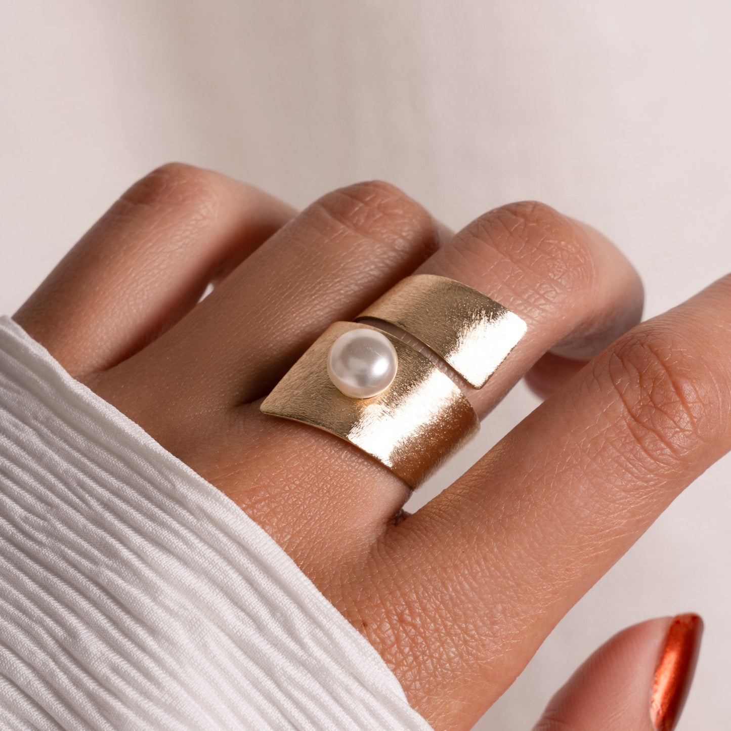 model wearing gold summer jewelry featuring pearl statement ring