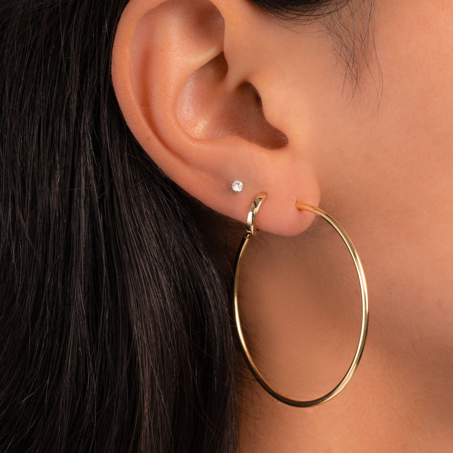 Model wearing skinny hoop earrings