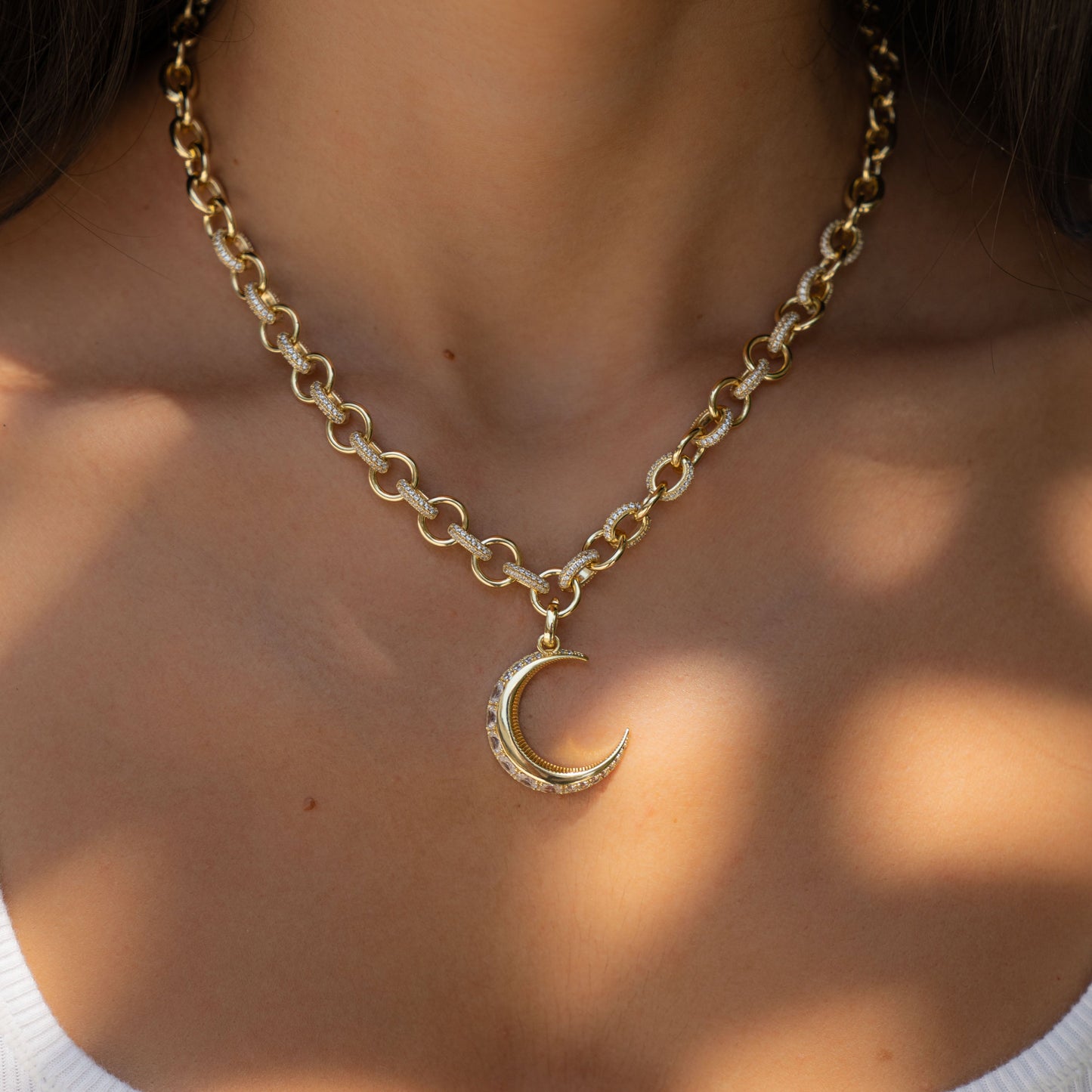 model wearing celestial statement necklace with gold chain and diamond moon charm