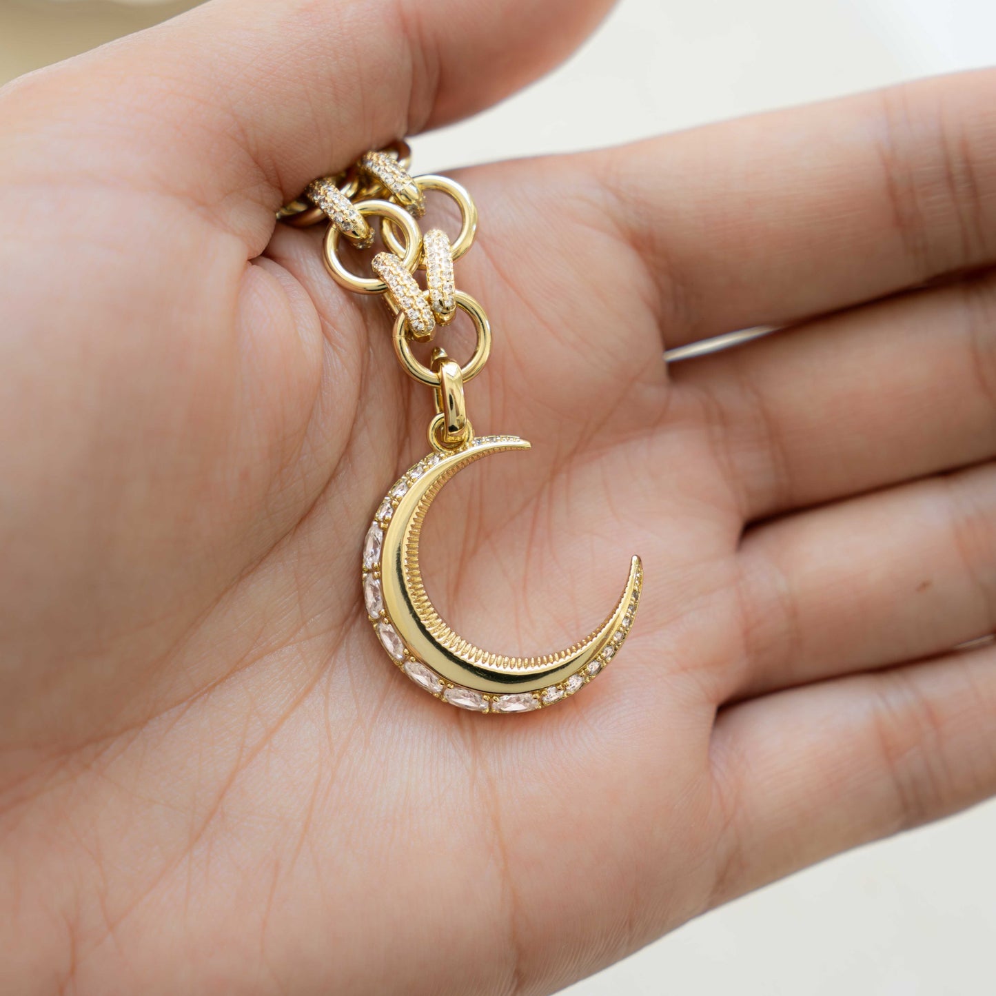 models hand showcasing diamond necklace with moon pendant