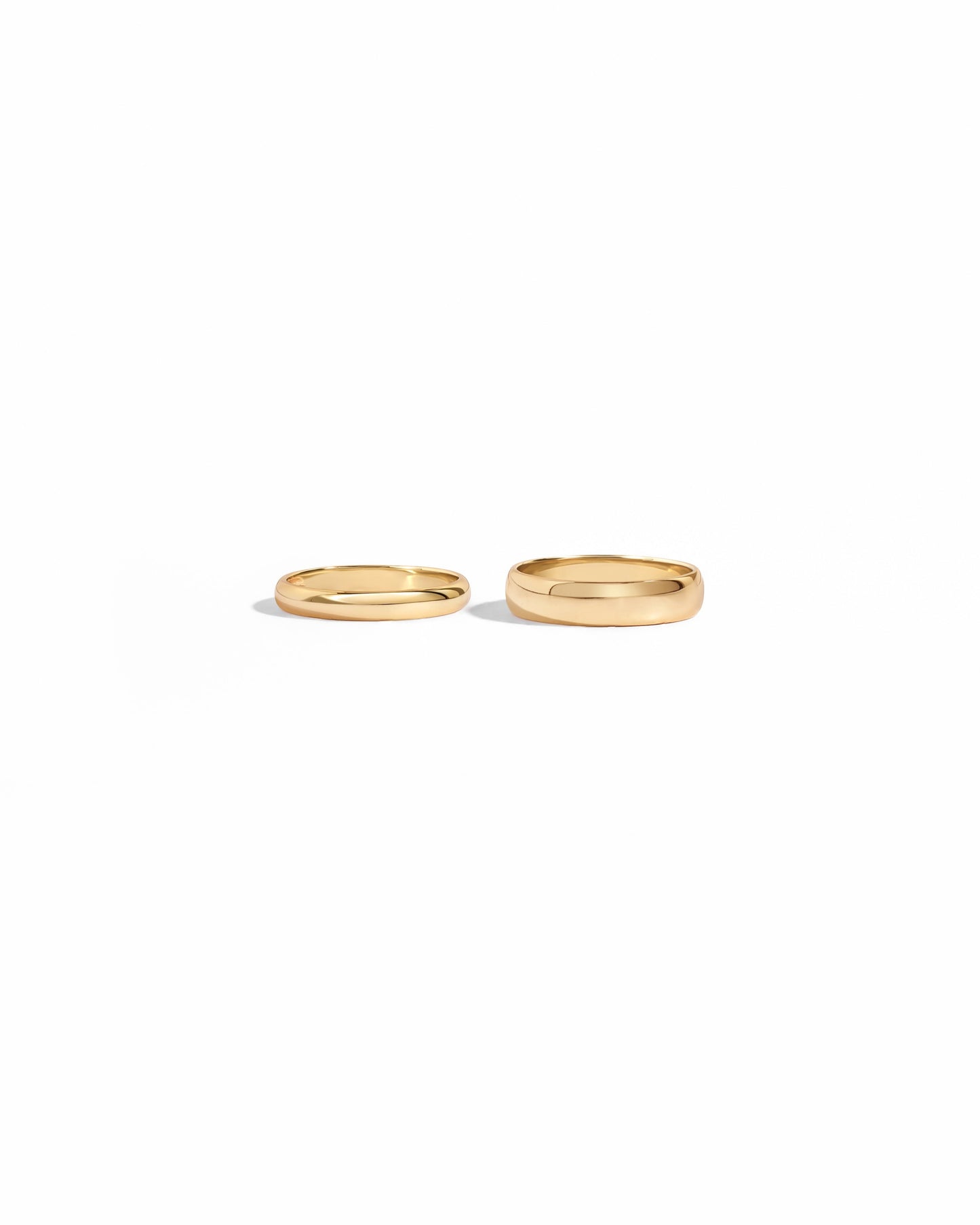 closeup image of 3mm plain gold band ring and 5mm plain eternity ring