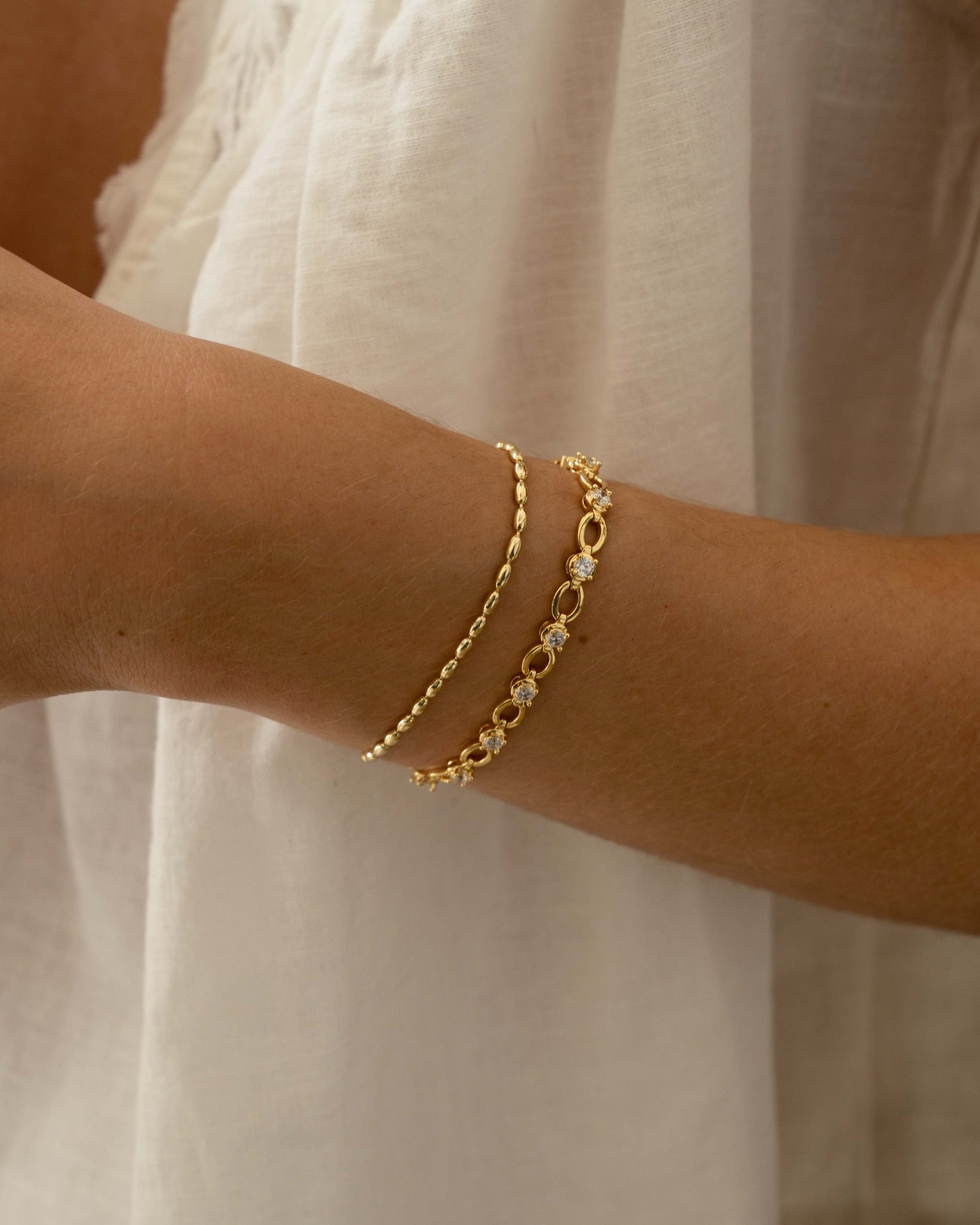 gold stacking bracelets on models wrist