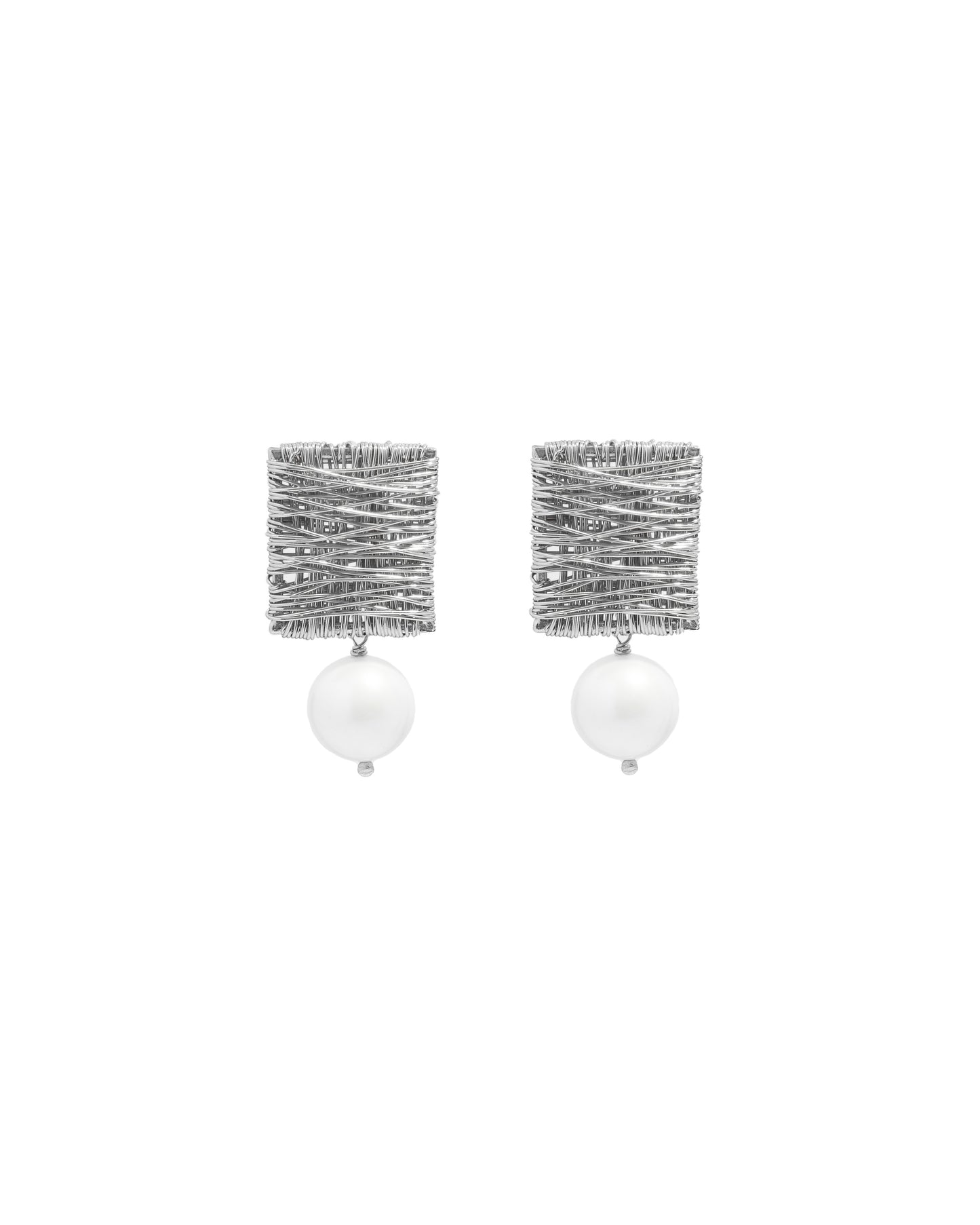 closeup image of silver dangle earrings with pearl charm