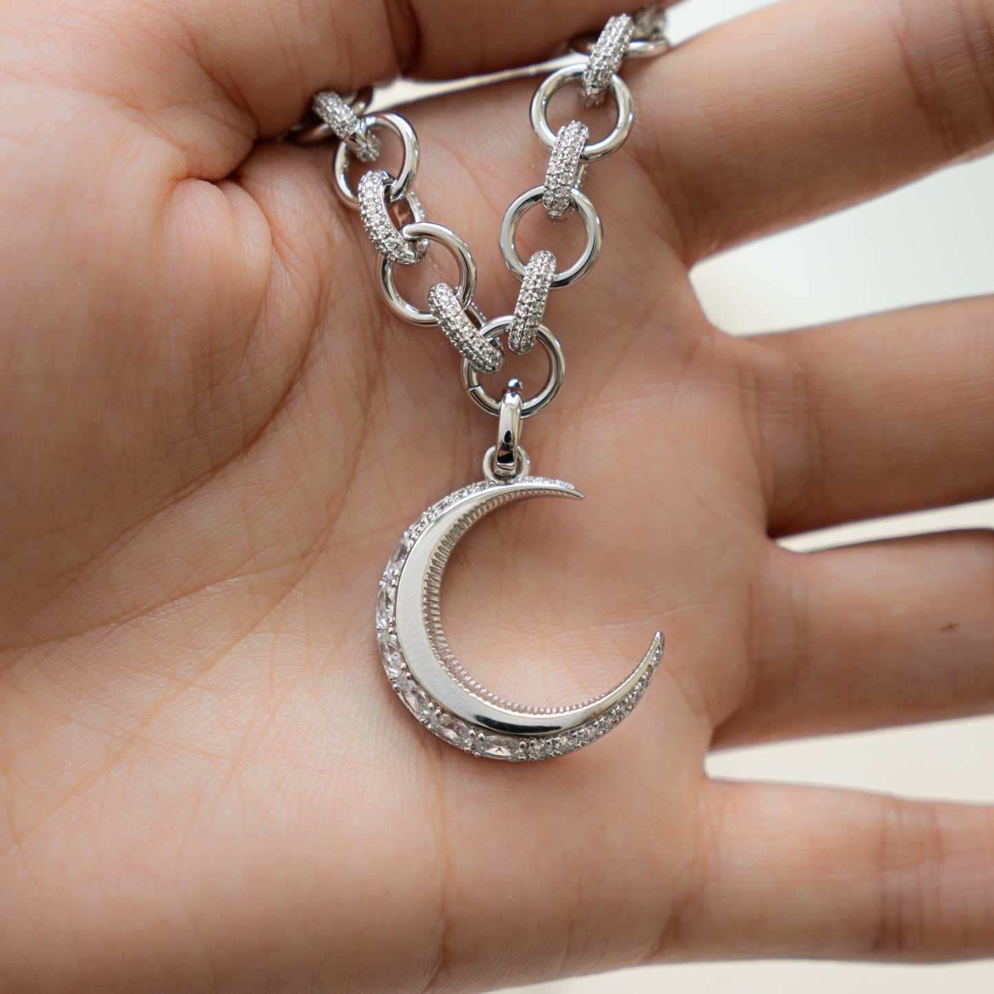 model holding silver pendant necklace with diamond moon pendant