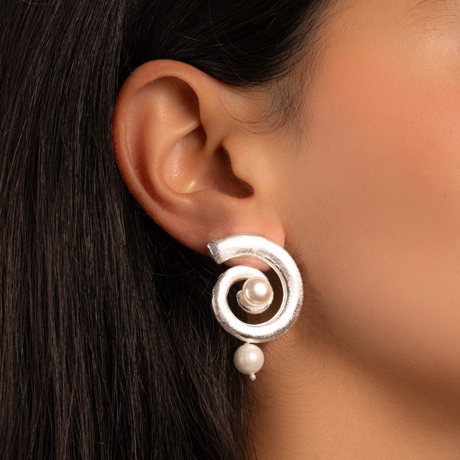 model wearing pearl charm earrings in silver