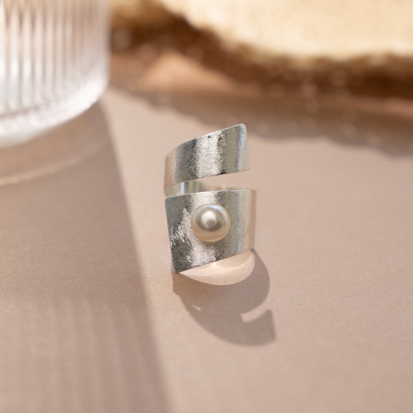 closeup image of boho jewelry featuring a statement ring with freshwater pearl