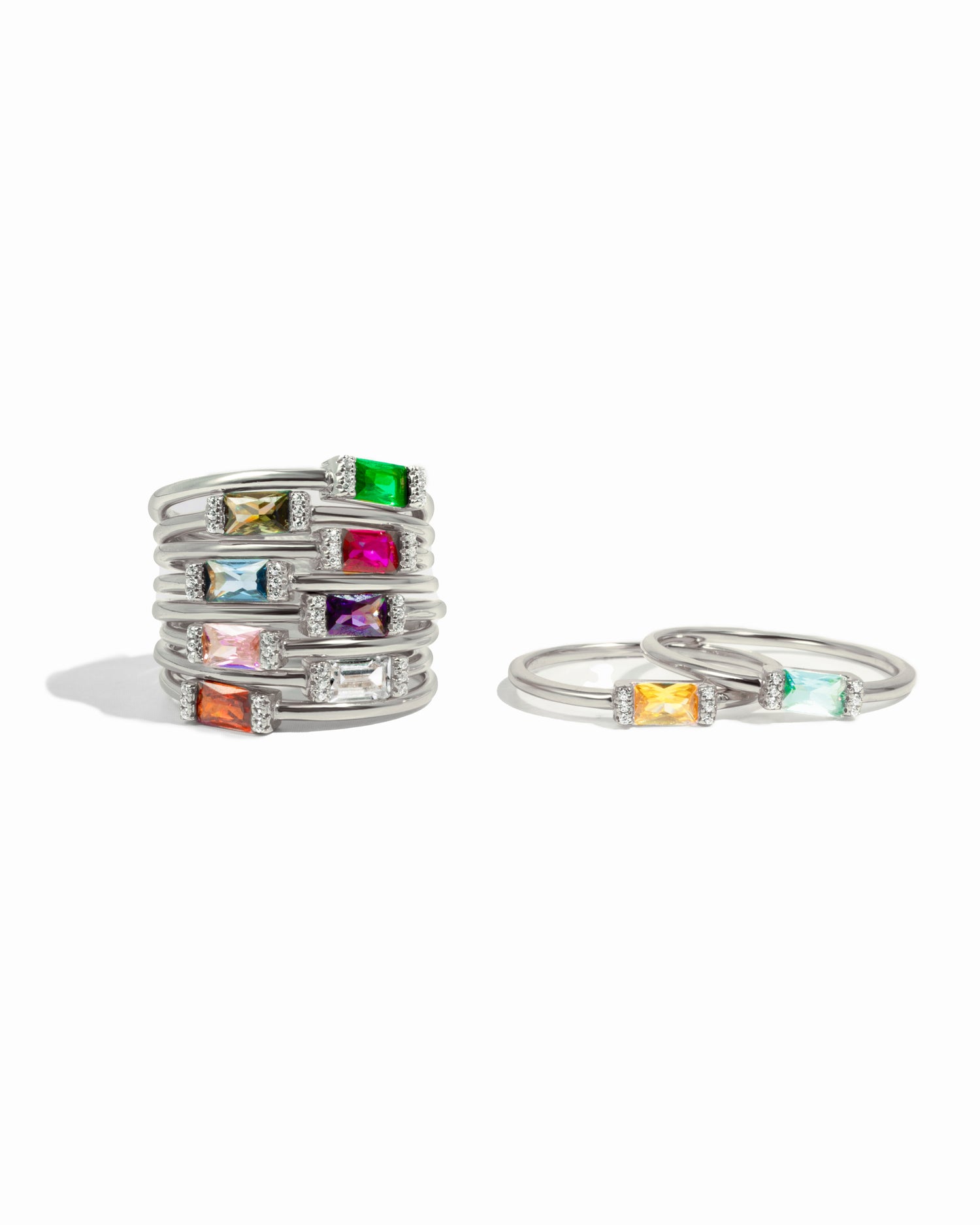 Simple baguette sterling silver birthstone rings in all birthstone gemstones on white background.